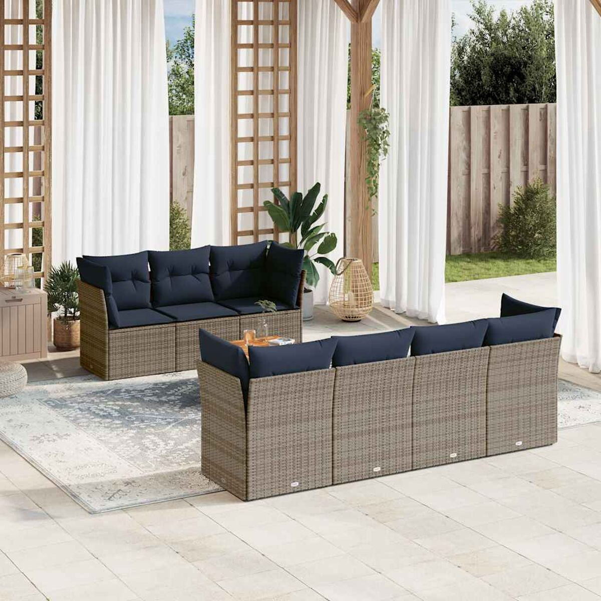 Set da patio all'aperto con cuscini blu, tende bianche e un tavolo. Mobili in rattan beige.