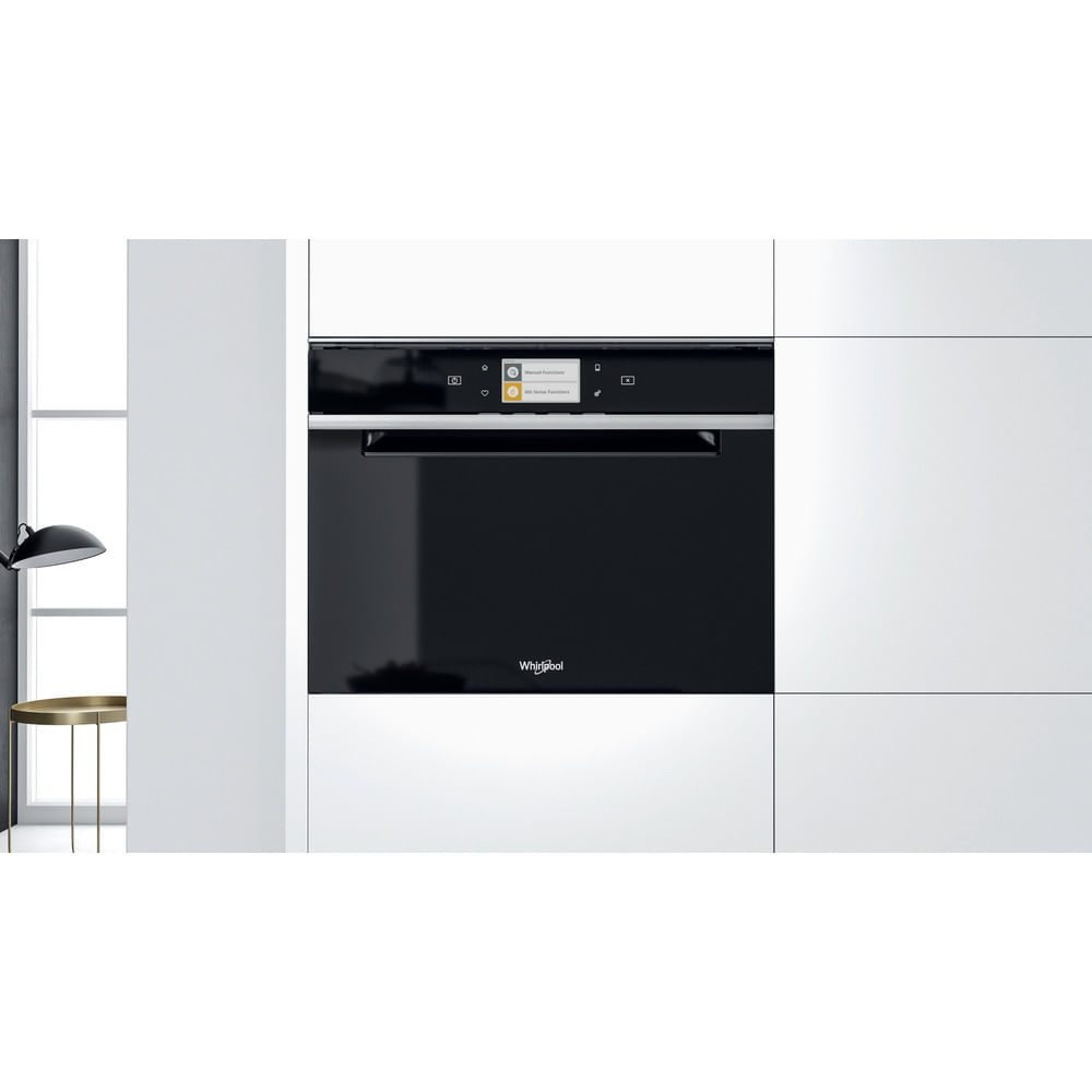 Forno Whirlpool nero integrato in un mobile da cucina bianco.