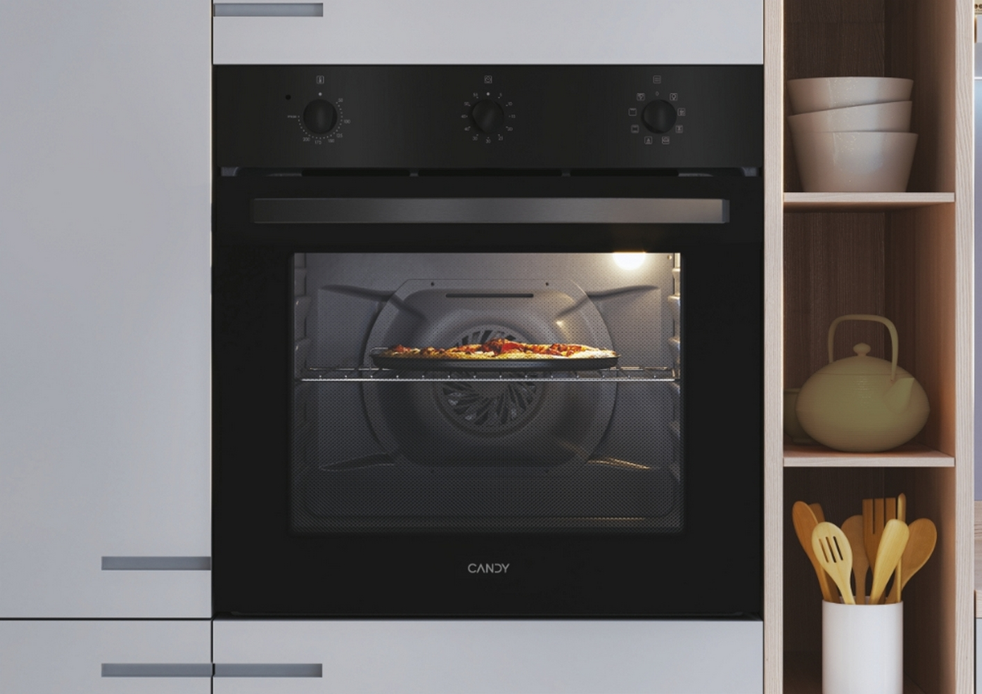 Un forno Candy nero con una pizza all'interno, in una cucina bianca.