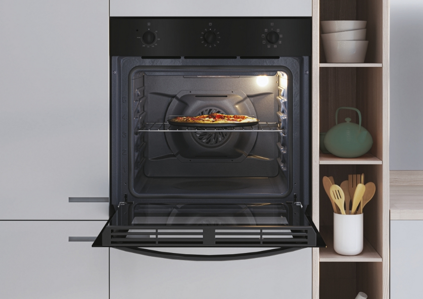 Forno con porta aperta e pizza all'interno. Ambiente cucina con mensole sullo sfondo.