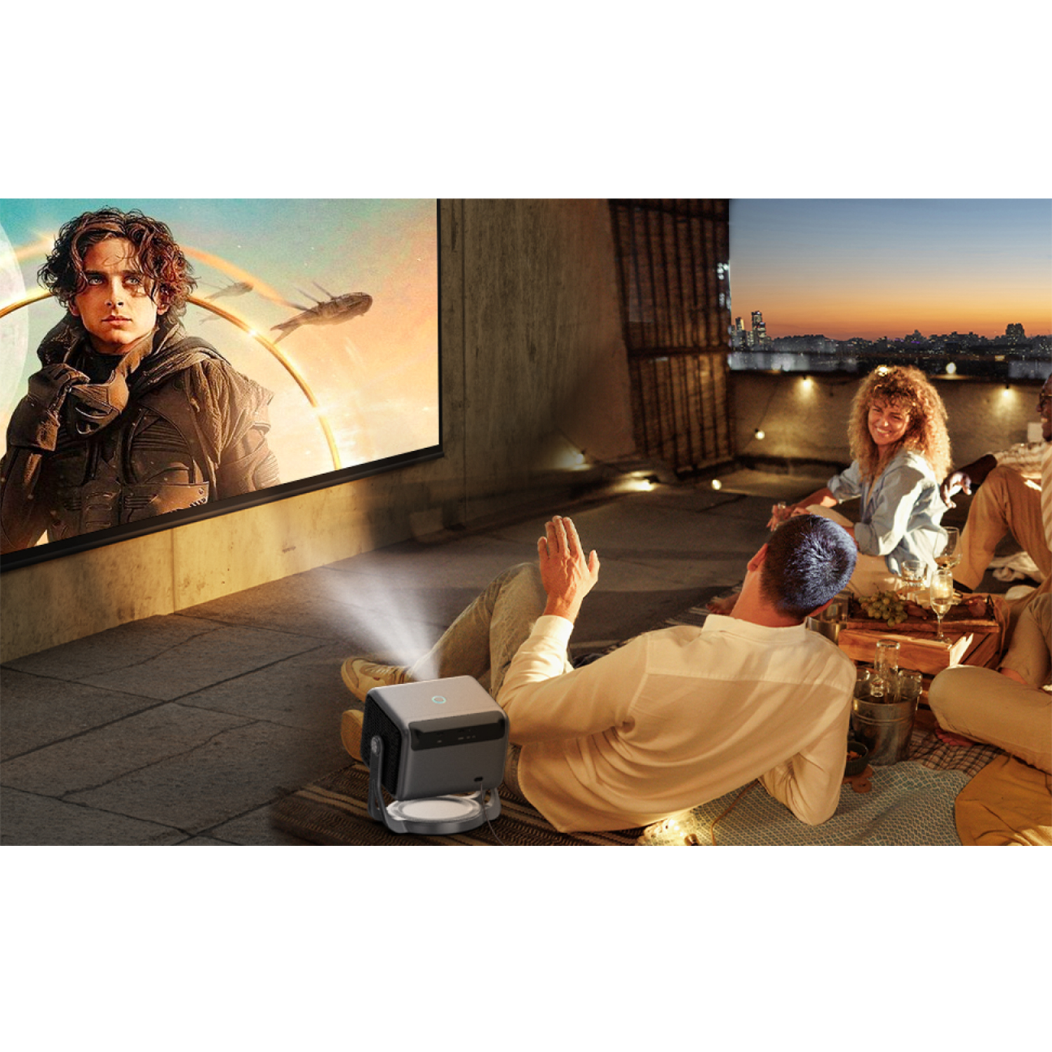 Grupa ludzi ogląda film na dachu. Projektor wyświetla film.