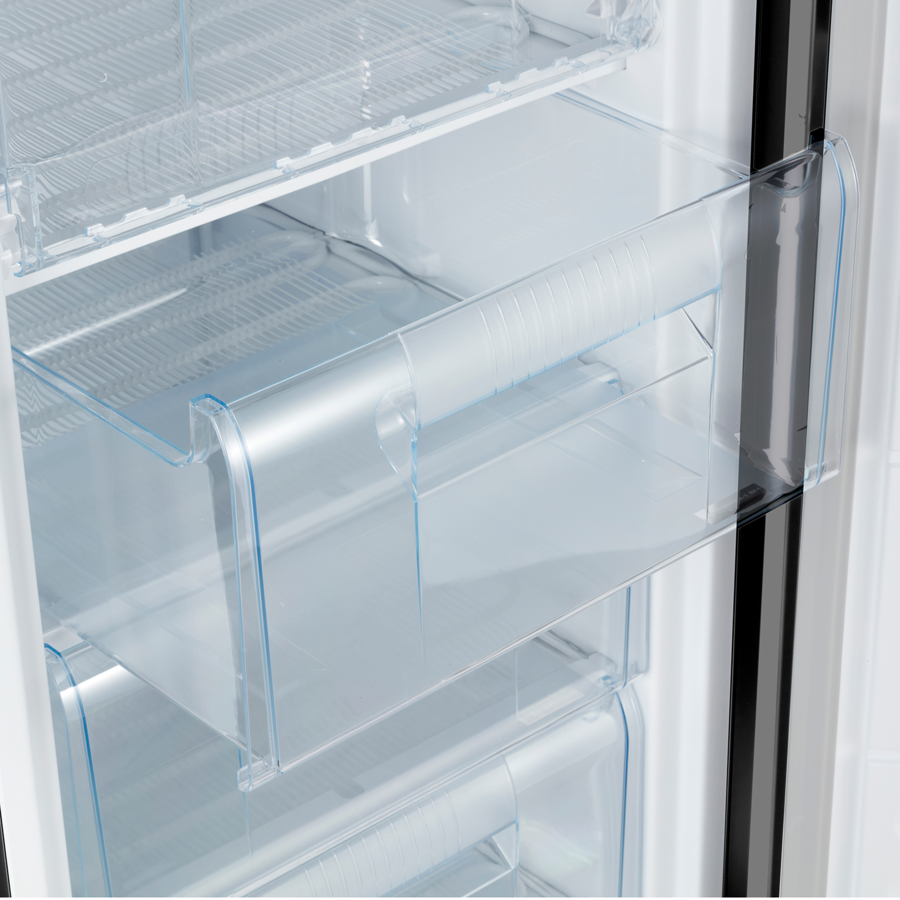 Primer plano de cajones de refrigerador transparentes con asas.
