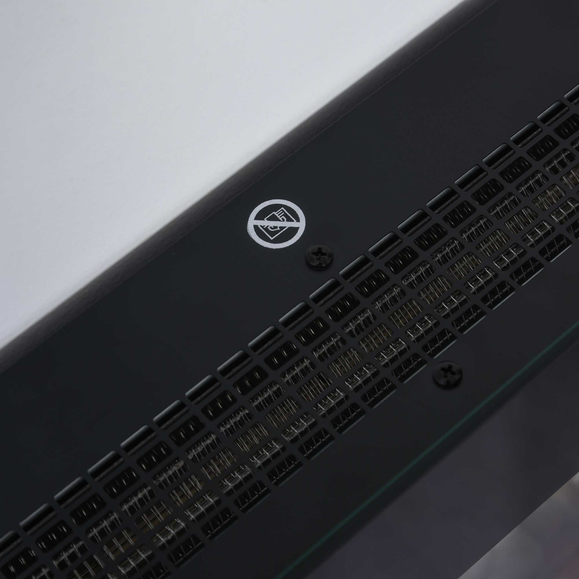 Nahaufnahme eines schwarzen elektronischen Geräts. Es gibt eine Lüftung mit Logo und Schrauben auf weißem Hintergrund.