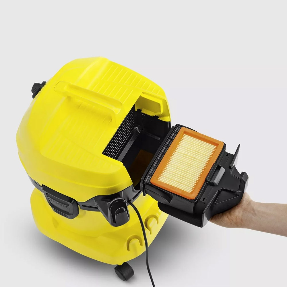 Aspirapolvere giallo con il filtro rimosso. Una mano tiene il filtro.