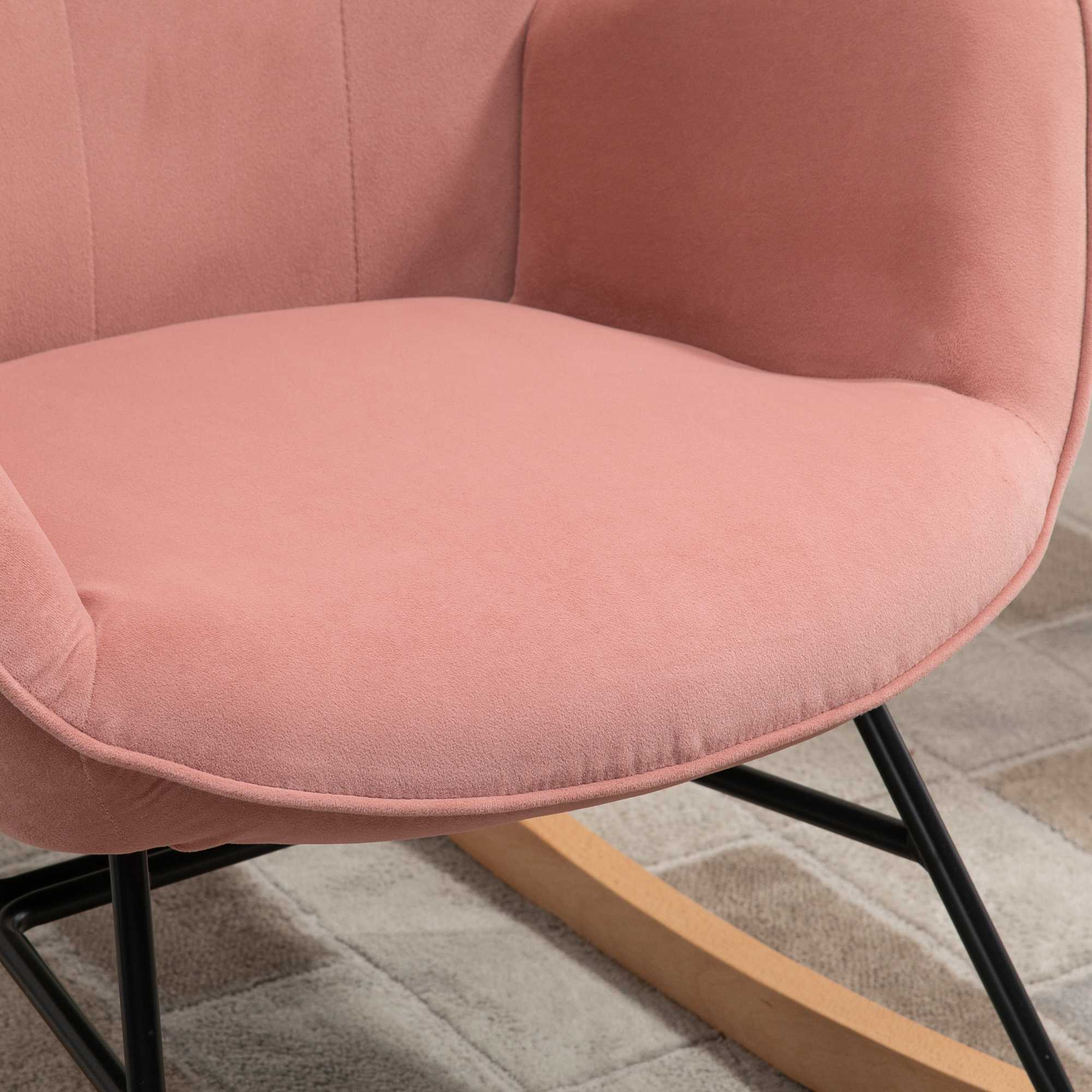 Nahaufnahme eines rosa Schaukelstuhls. Der Stuhl hat einen abgerundeten Sitz und eine geschwungene Rückenlehne.