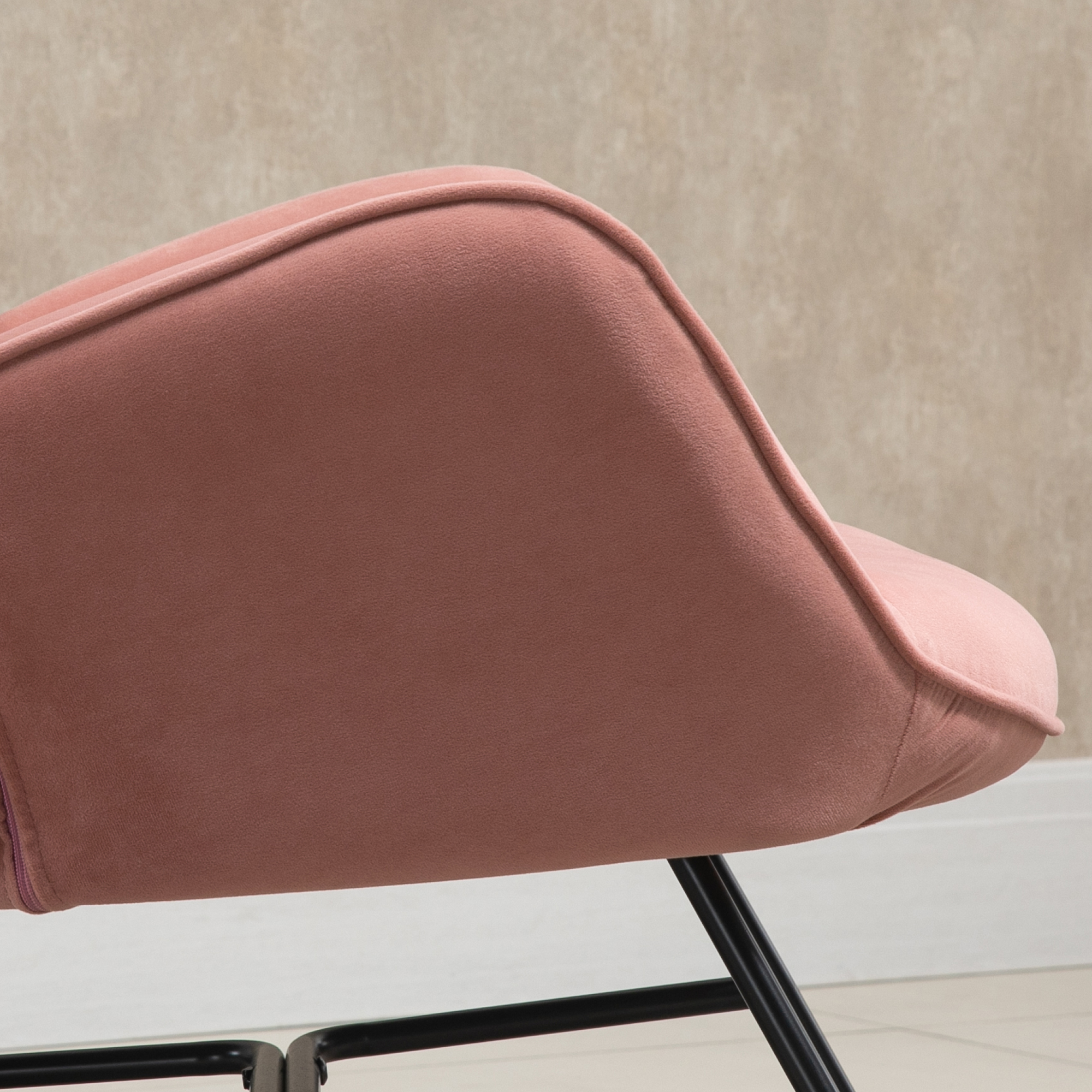 Ein rosa Stuhl mit schwarzem Metallrahmen, Nahaufnahme der Rückenlehne.