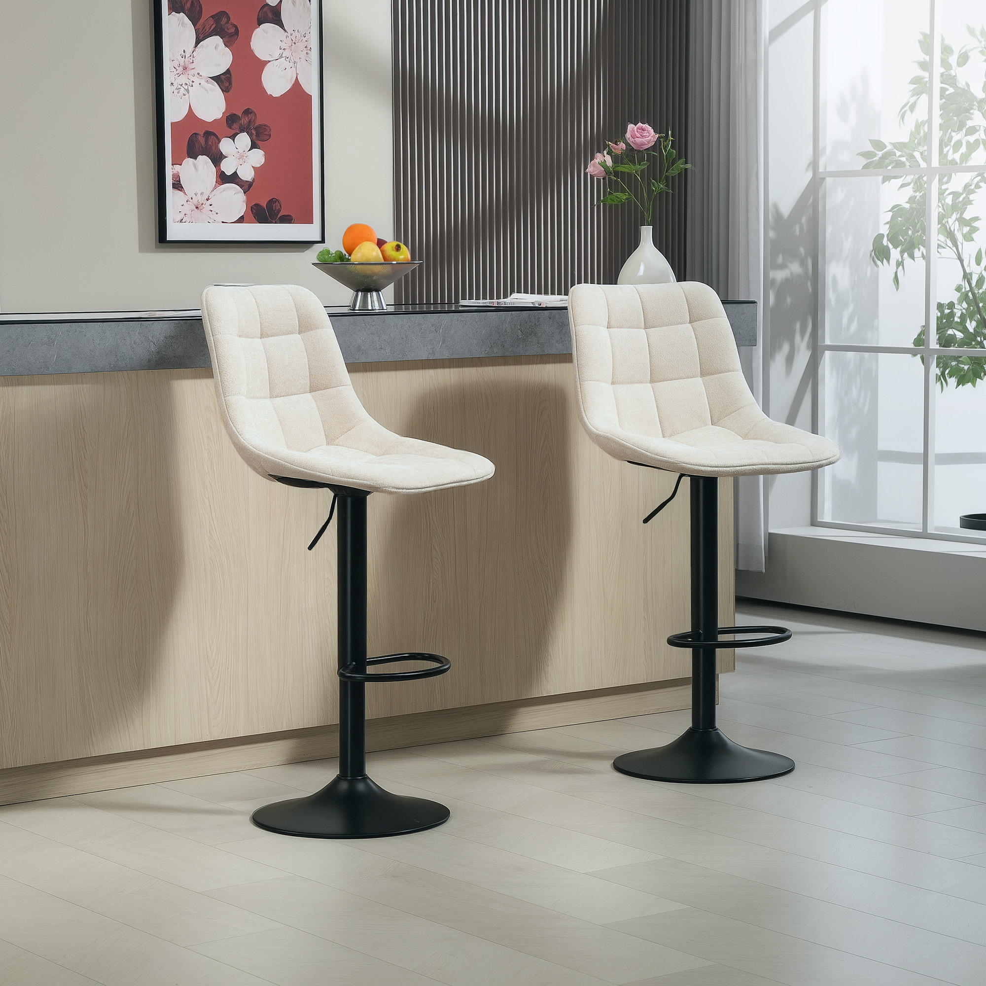 Zwei beige, getuftete Barhocker mit schwarzen Sockeln vor einer Küchenarbeitsplatte.