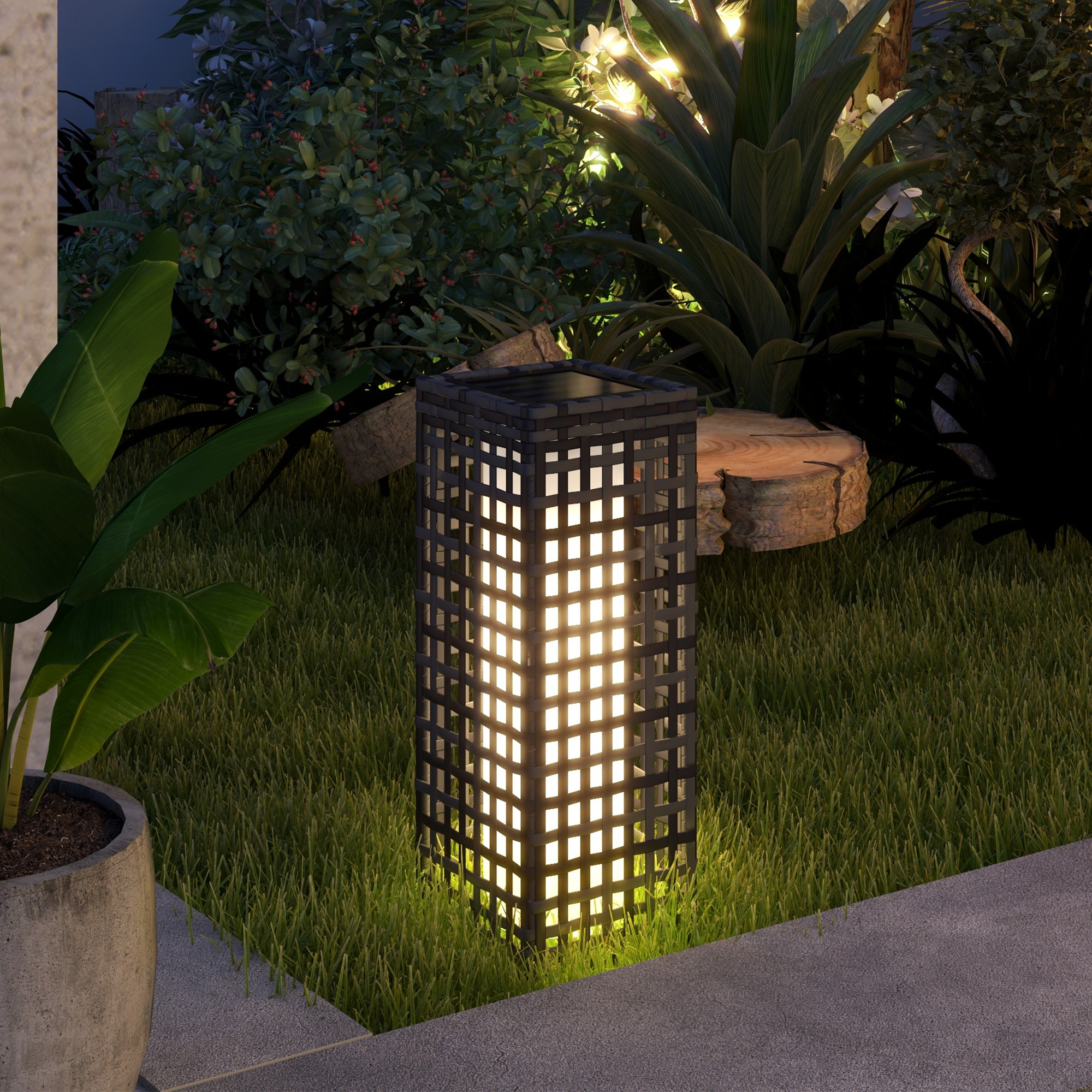 Eine schwarze Außenlaterne mit Gitterdesign. Es ist beleuchtet und auf dem Gras.