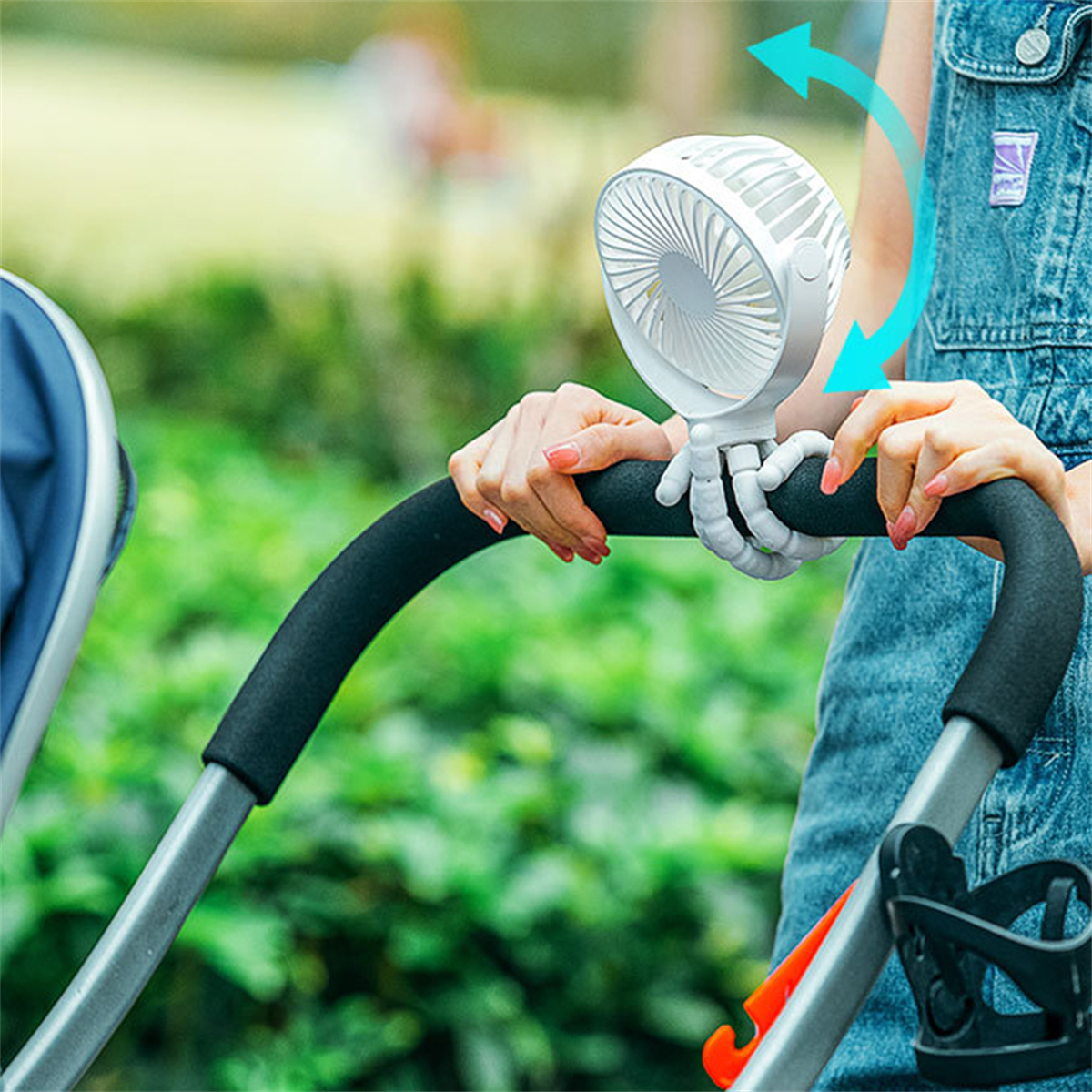 Ventilator an einem Kinderwagengriff mit flexiblem Griff befestigt, von einer Person gehalten.