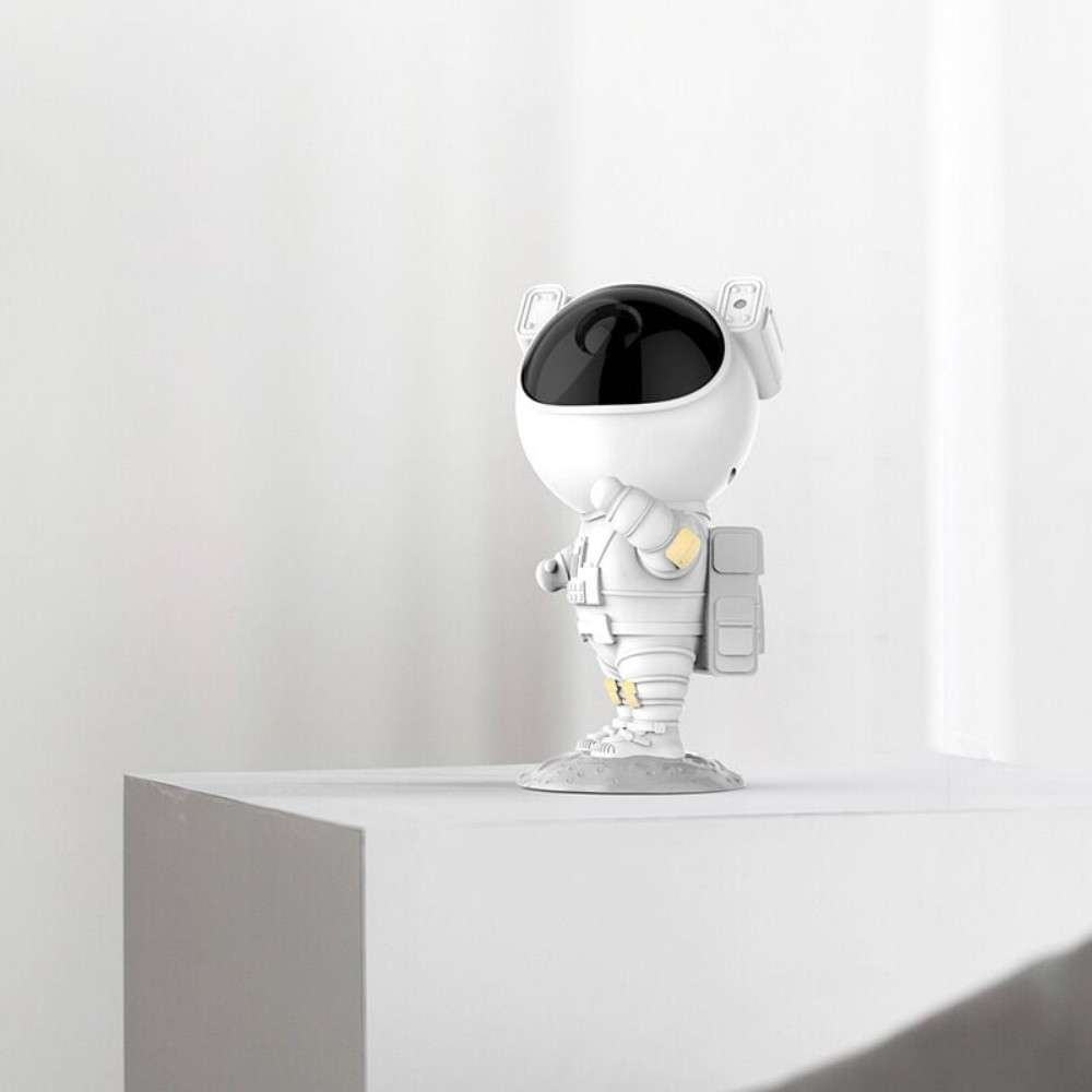 Weiße Astronautenfigur, die auf einem weißen Block steht. Es befindet sich auf einem weißen Hintergrund.