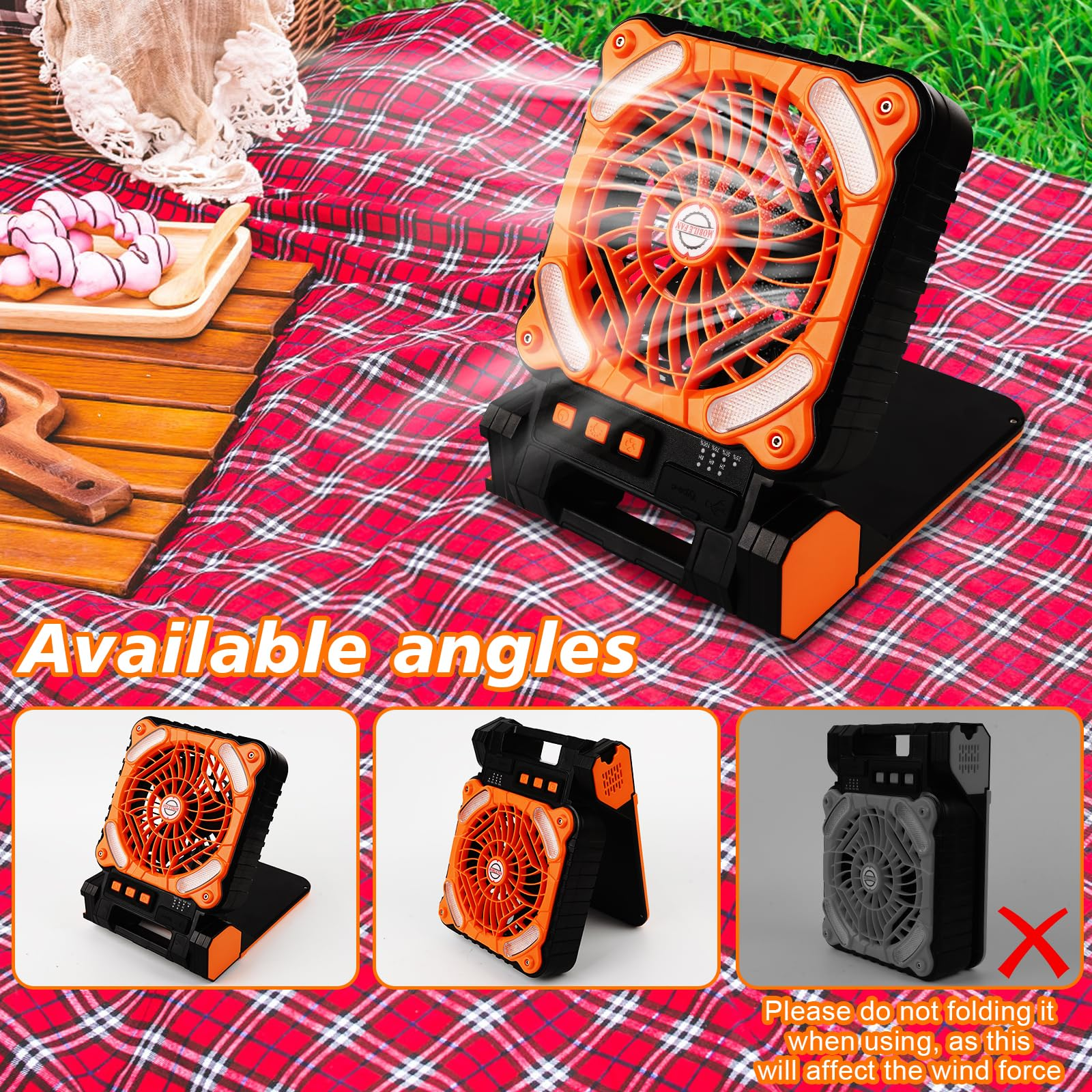 Ein tragbarer Ventilator auf einer Picknickdecke. Er ist orange und schwarz und hat verschiedene Winkel.