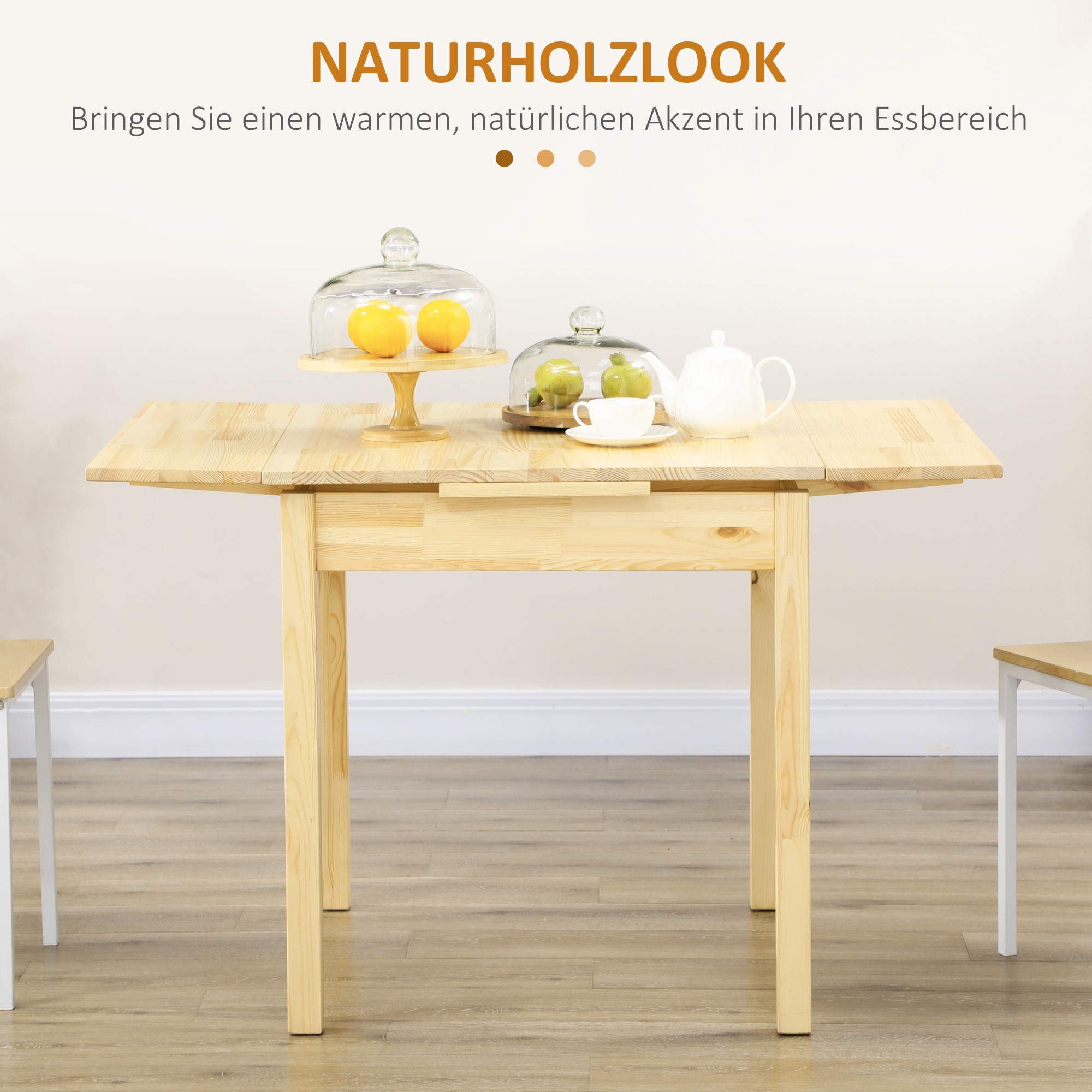Holztisch mit ausziehbaren Blättern, mit Früchten und einem Teeservice darauf.