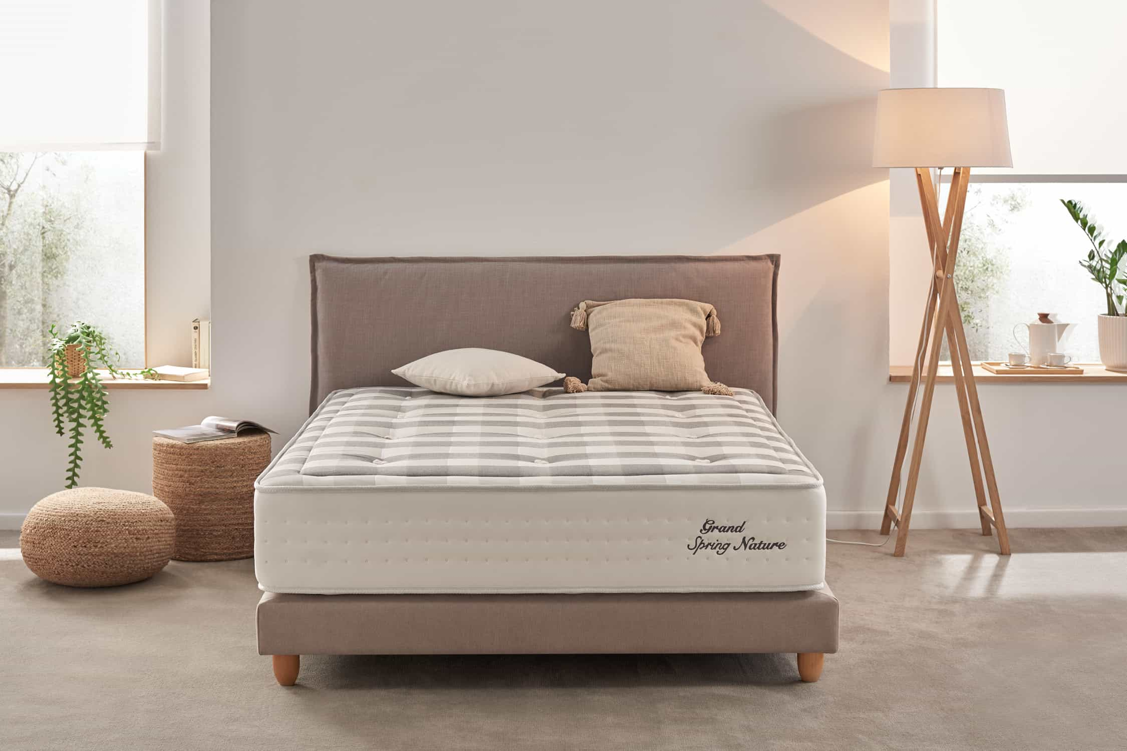 Dormitorio con cama y lámpara. Colchón a rayas con almohadas.