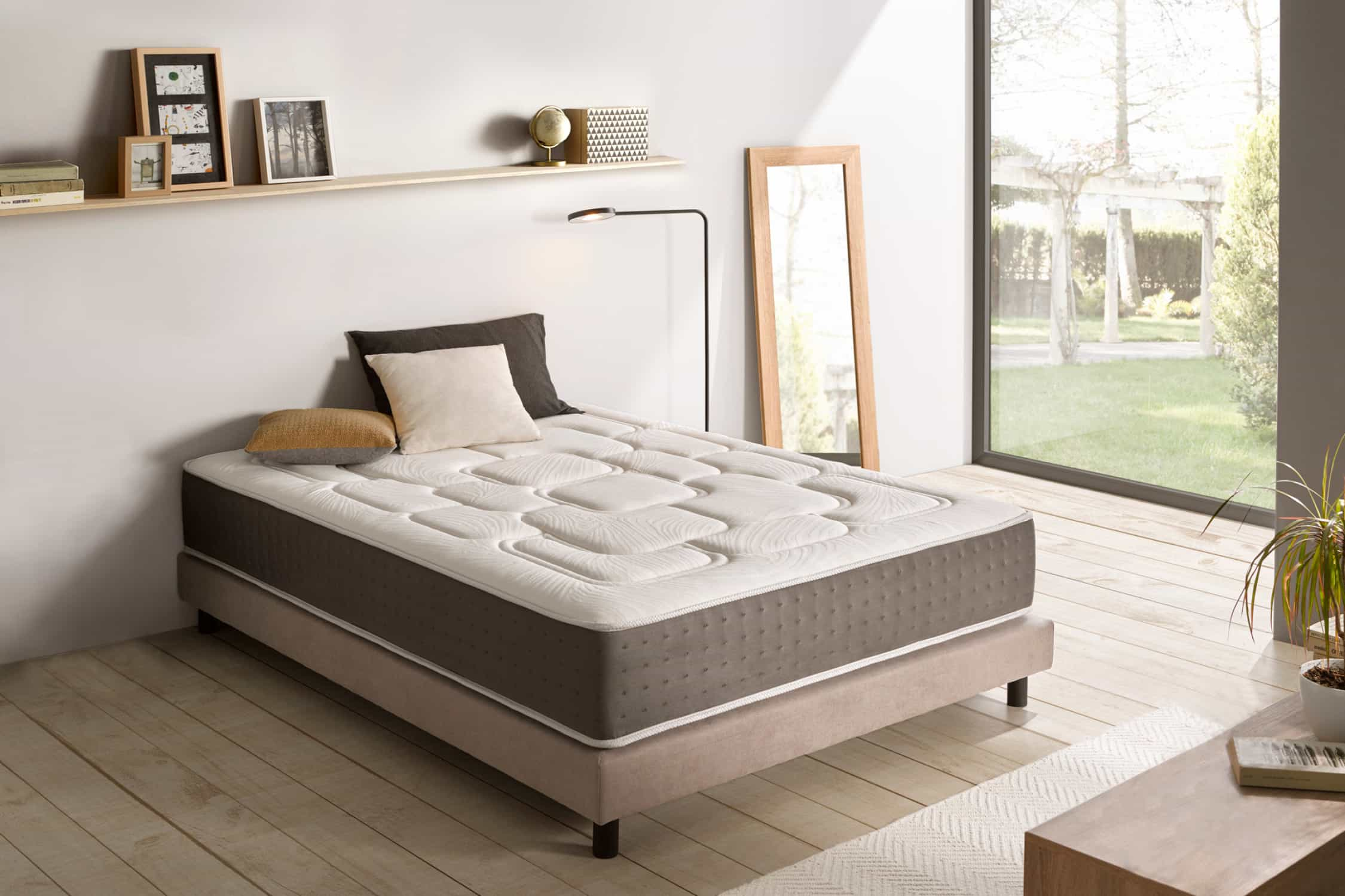 Cama con colch ón, almohadas, espejo, estante y decoración.