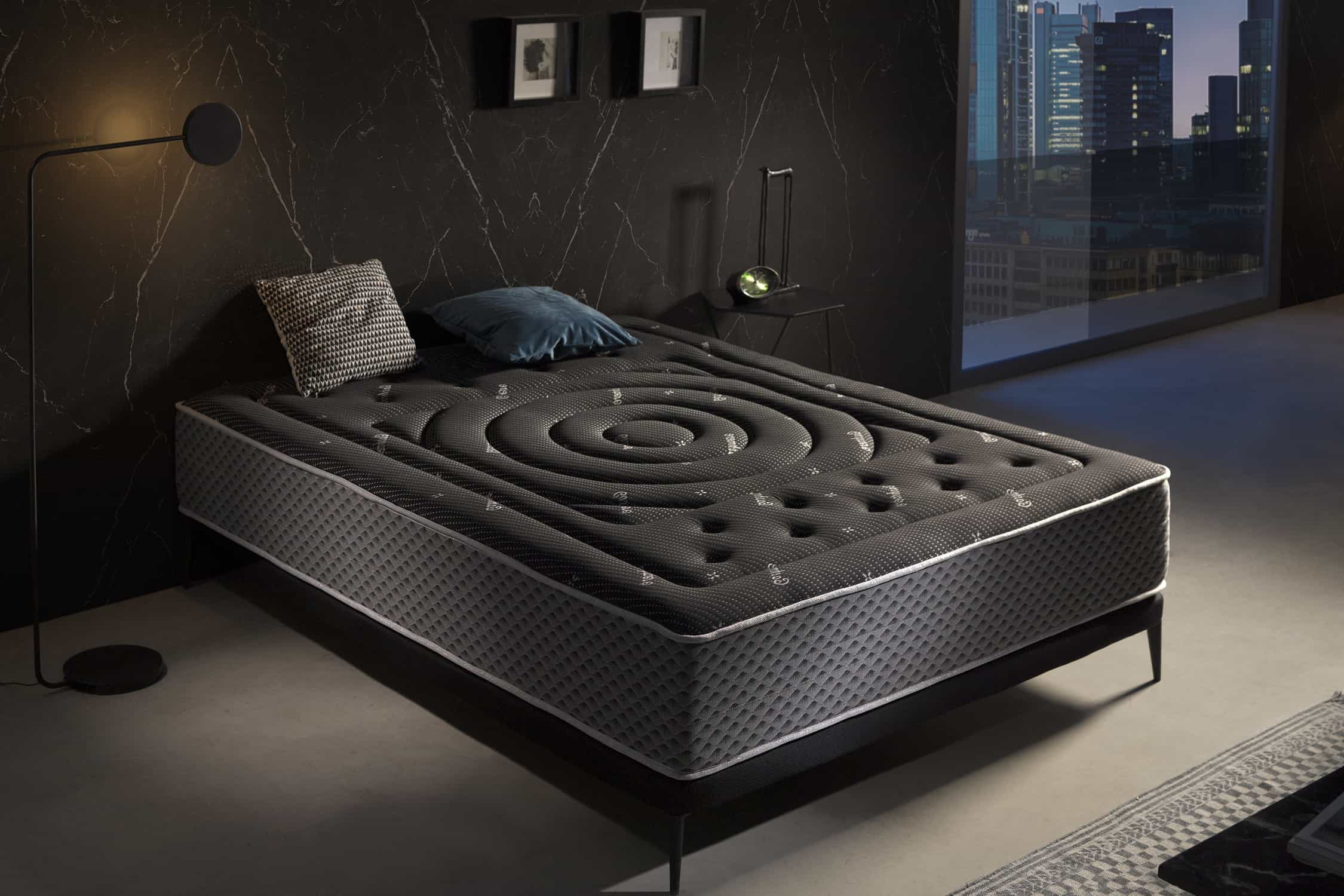 Dormitorio con una cama con colchón negro. La cama tiene un colchón gris oscuro.