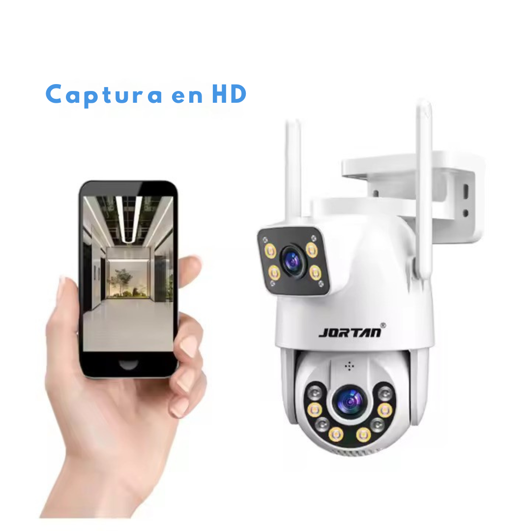 Una mano sostiene un teléfono que muestra una imagen interior, con una cámara de seguridad a la derecha.