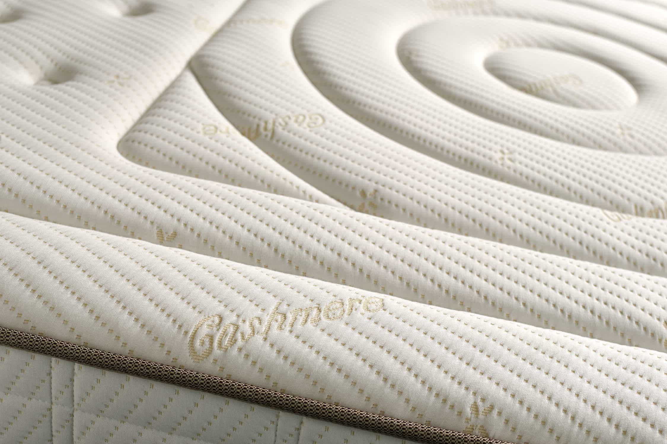 Primer plano de un colchón con superficie crema y diseño en espiral.