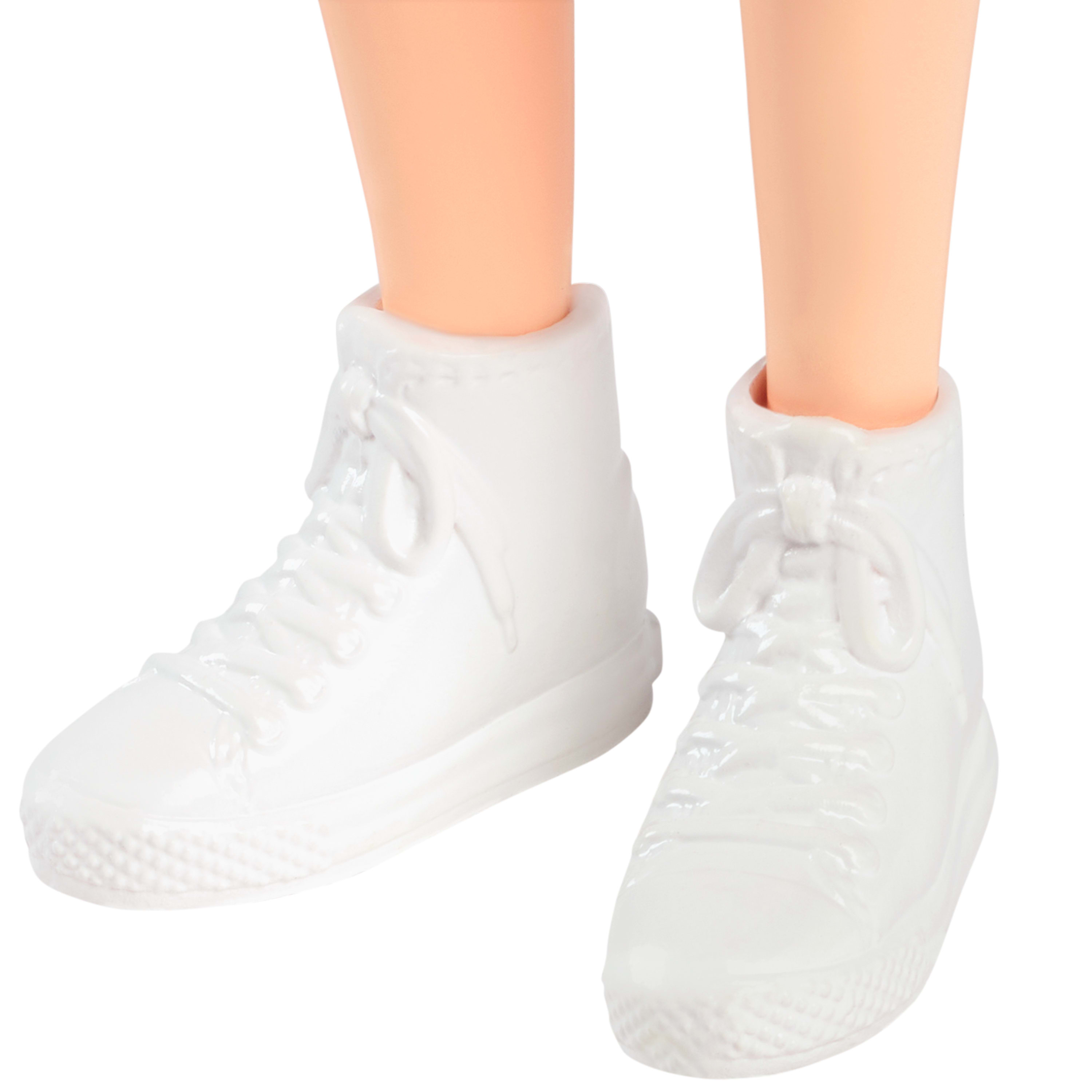 Para białych tenisówek lalki. Trampki są wiązane białymi sznurowadłami.