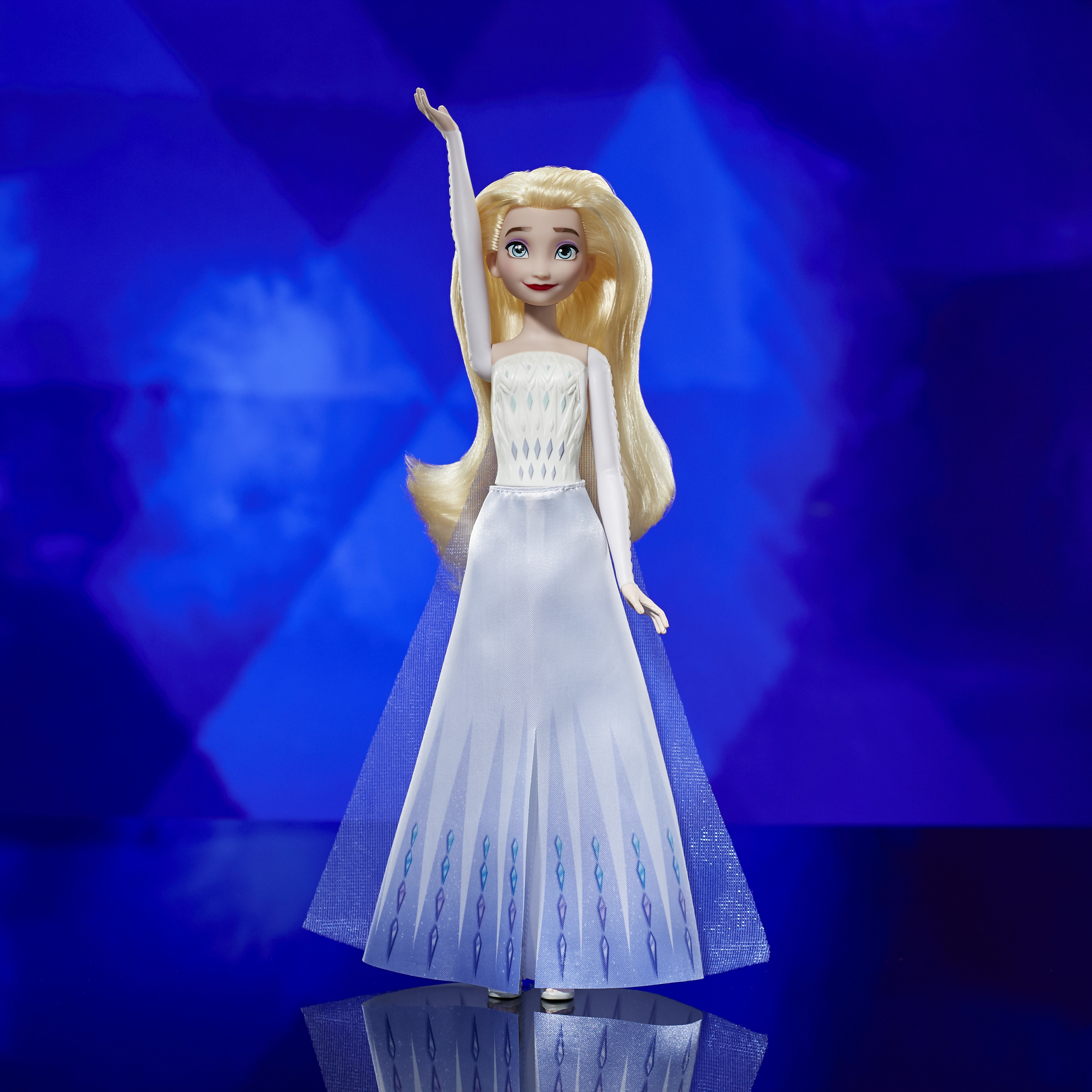 Elsa-Puppe aus Frozen, in weißem Kleid mit langen blonden Haaren, hebt den rechten Arm.