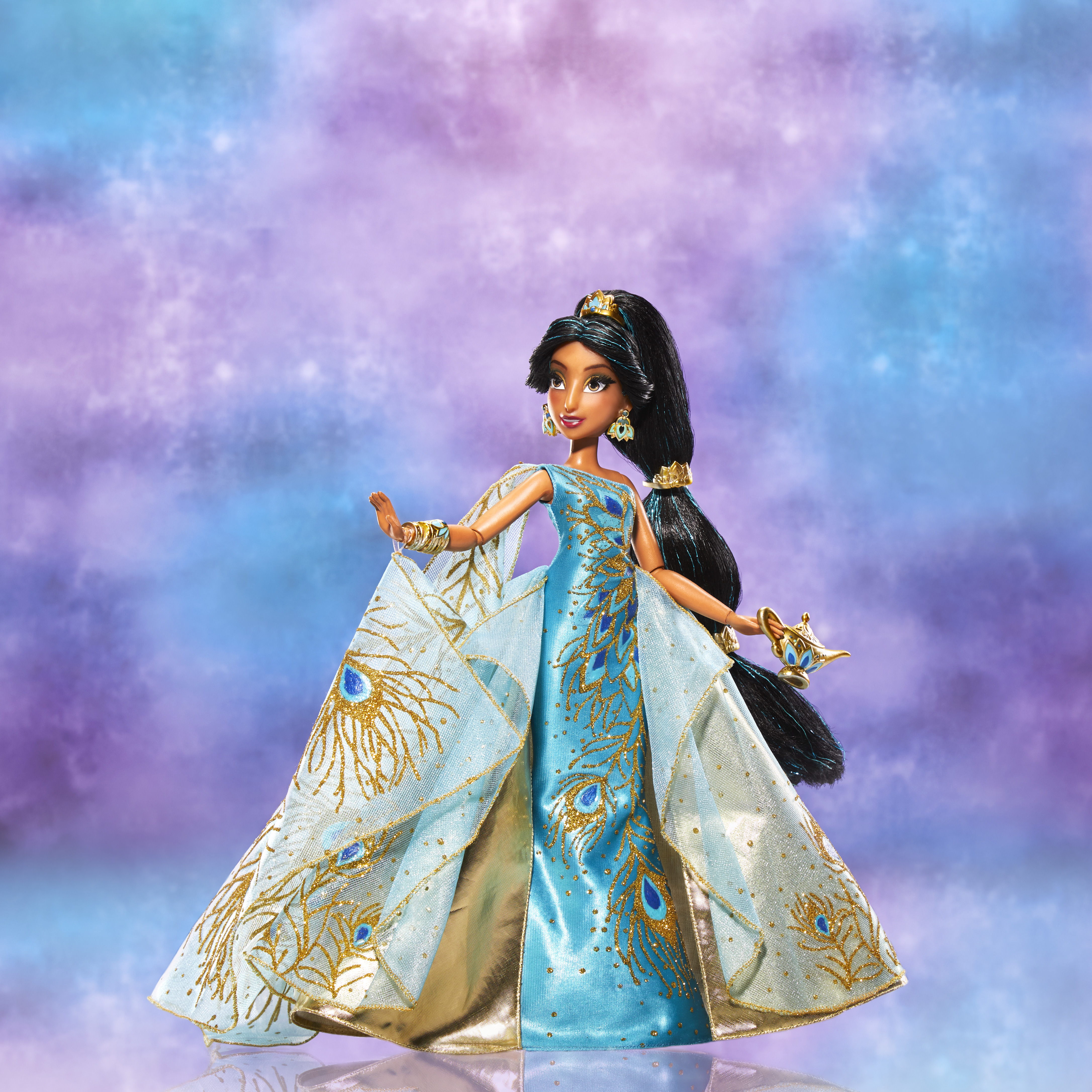 Jasmine-Puppe in einem blauen Kleid mit Pfauenfedern-Design. Sie hält eine goldene Lampe.