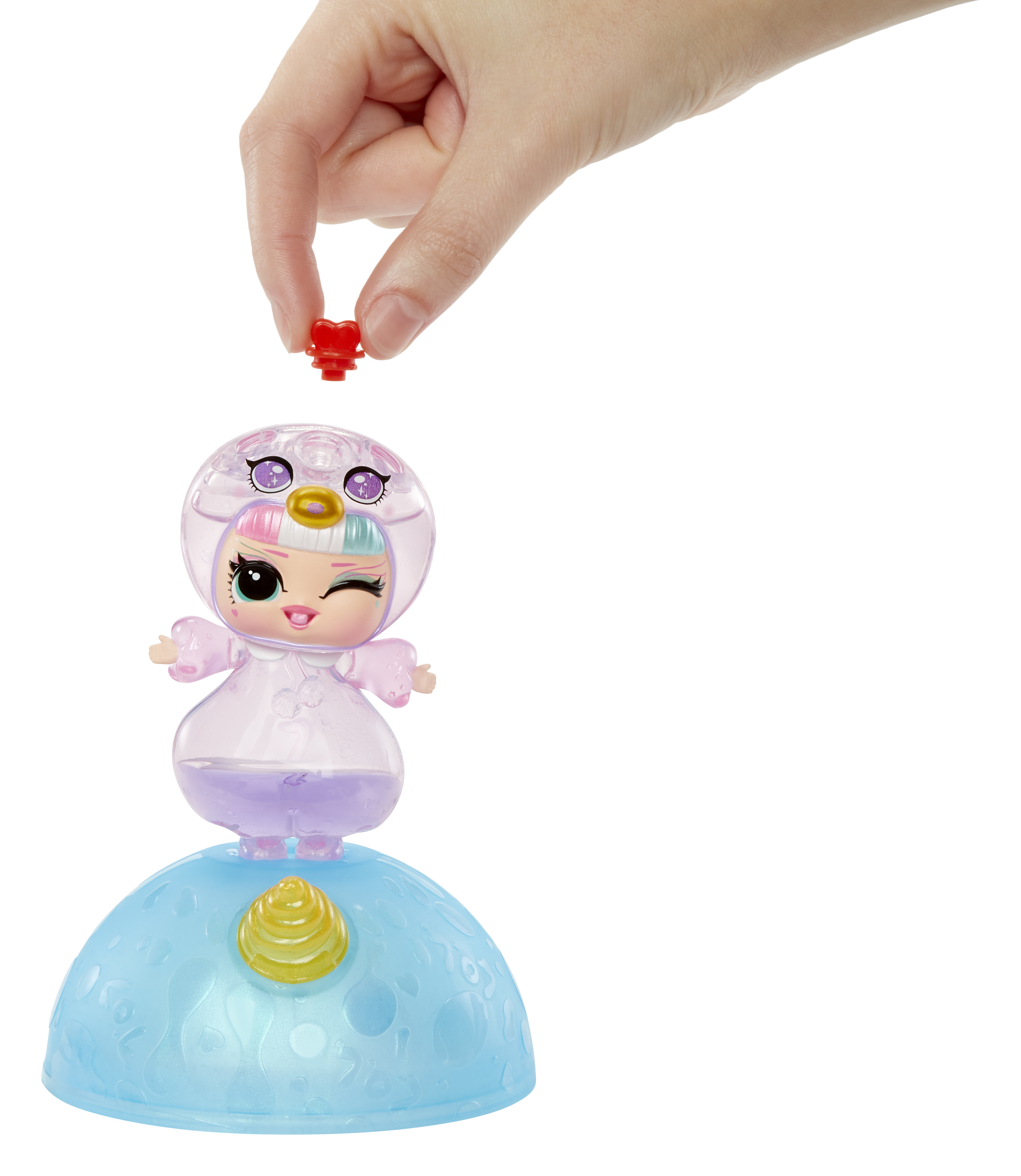 Una pequeña muñeca con una cúpula transparente y un objeto rojo que se coloca encima.