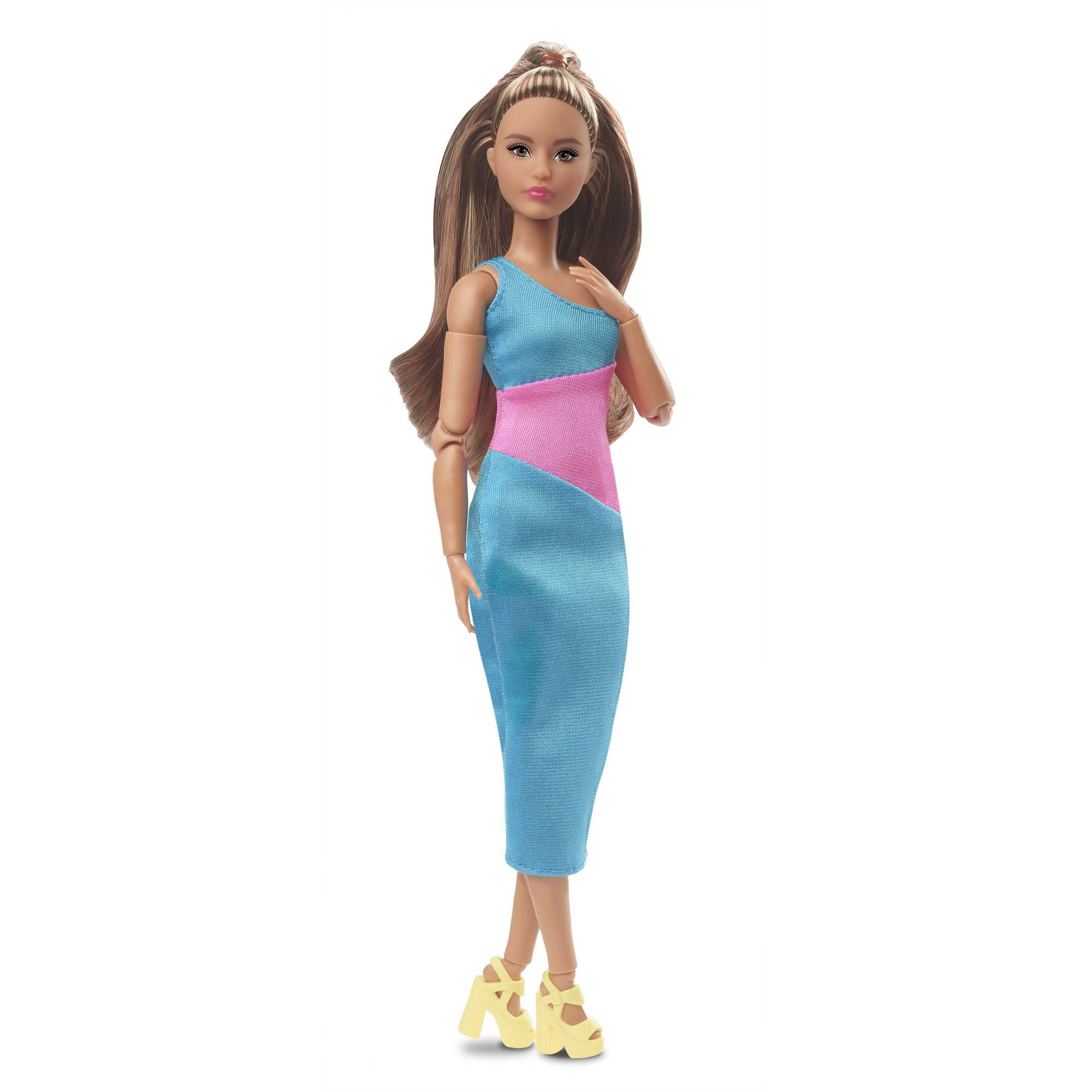 Puppe in einem blauen Kleid mit pinken und blauen Panels und gelben Absätzen. Steht auf weißem Hintergrund.