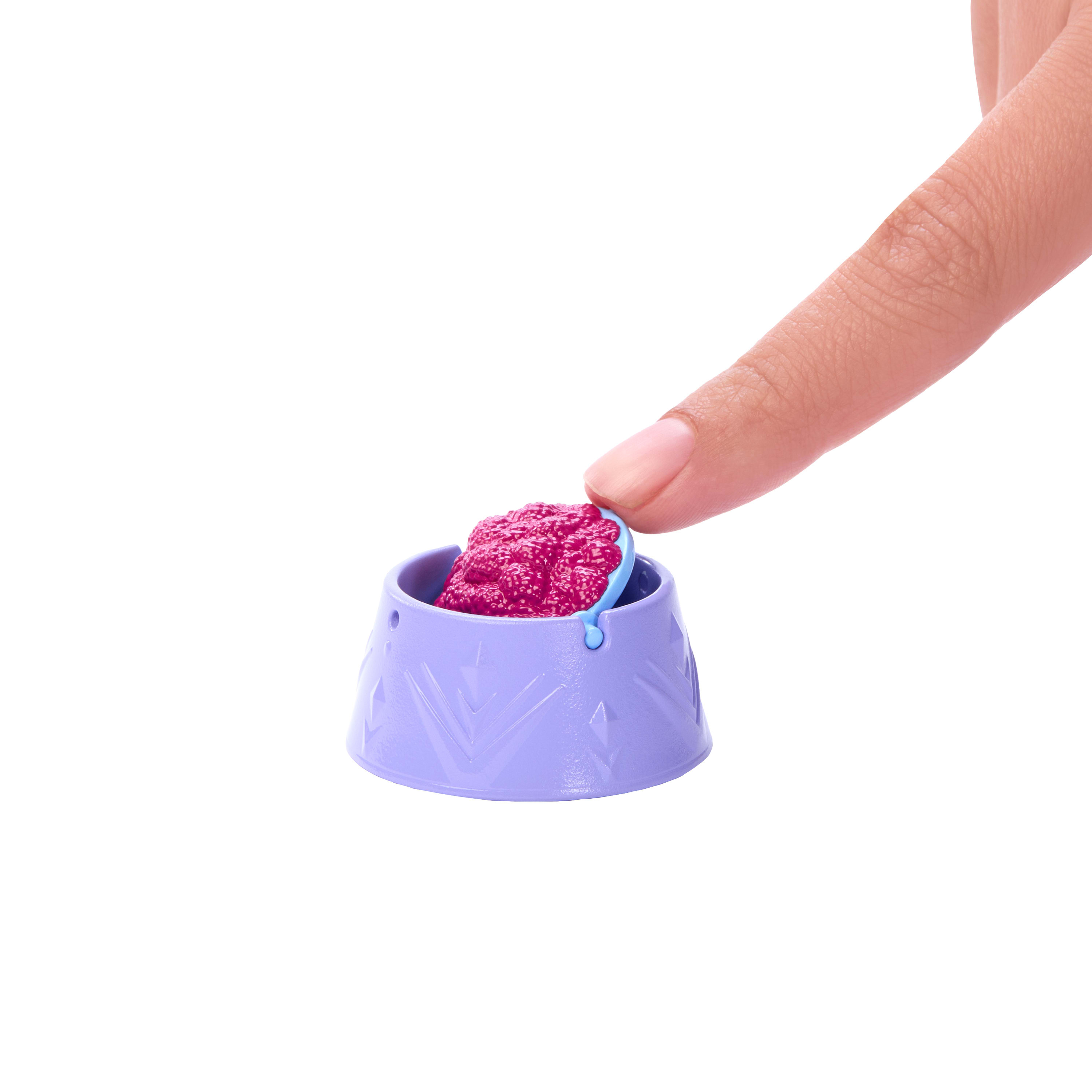 Palec dotyka fioletowej miski z różowym jedzeniem. Tło jest białe.