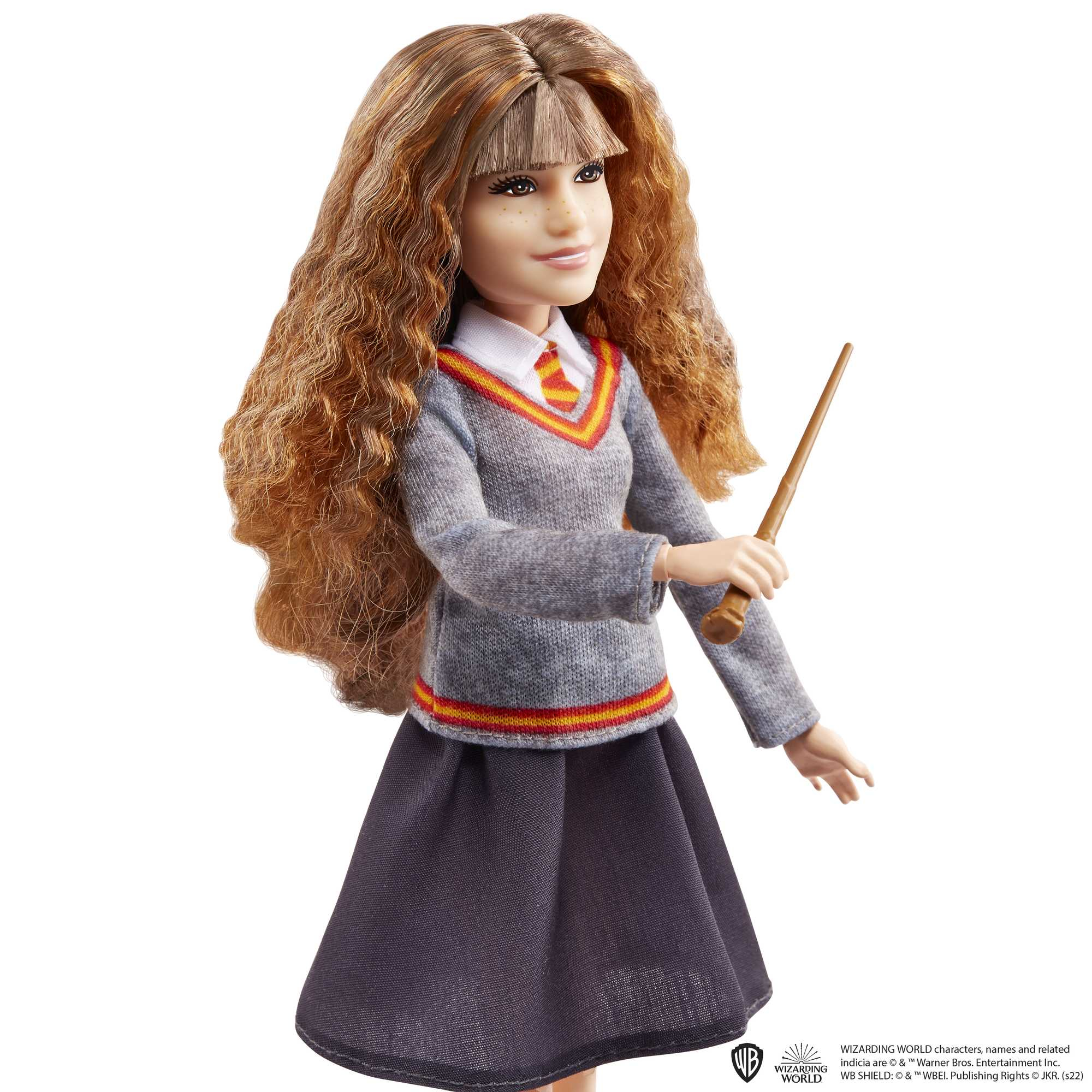 Eine Puppe von Hermine Granger in ihrer Hogwarts-Uniform, die einen Zauberstab hält. Sie hat lange, lockige, braune Haare.