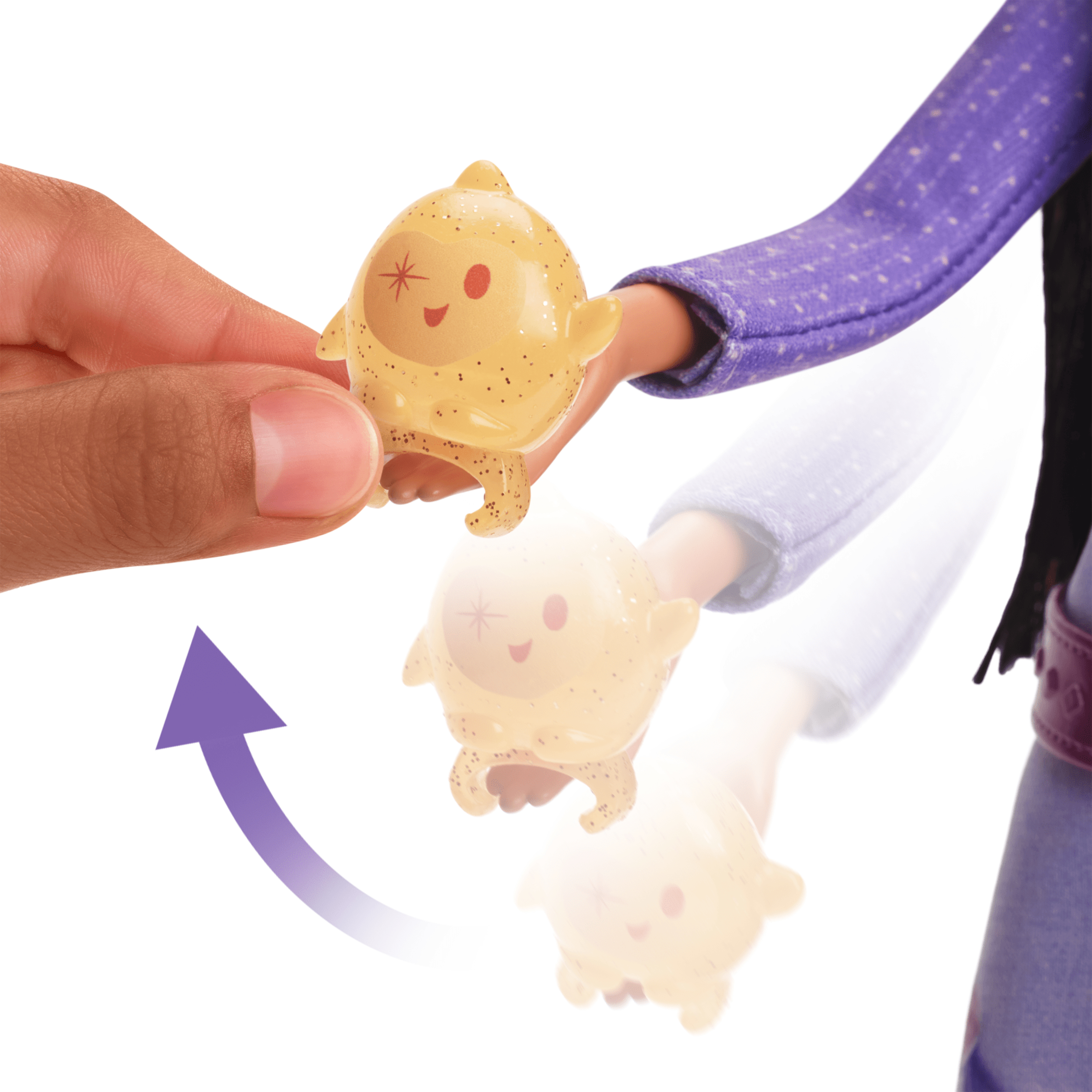 Eine Hand bewegt ein kleines Spielzeug auf eine Puppe zu.