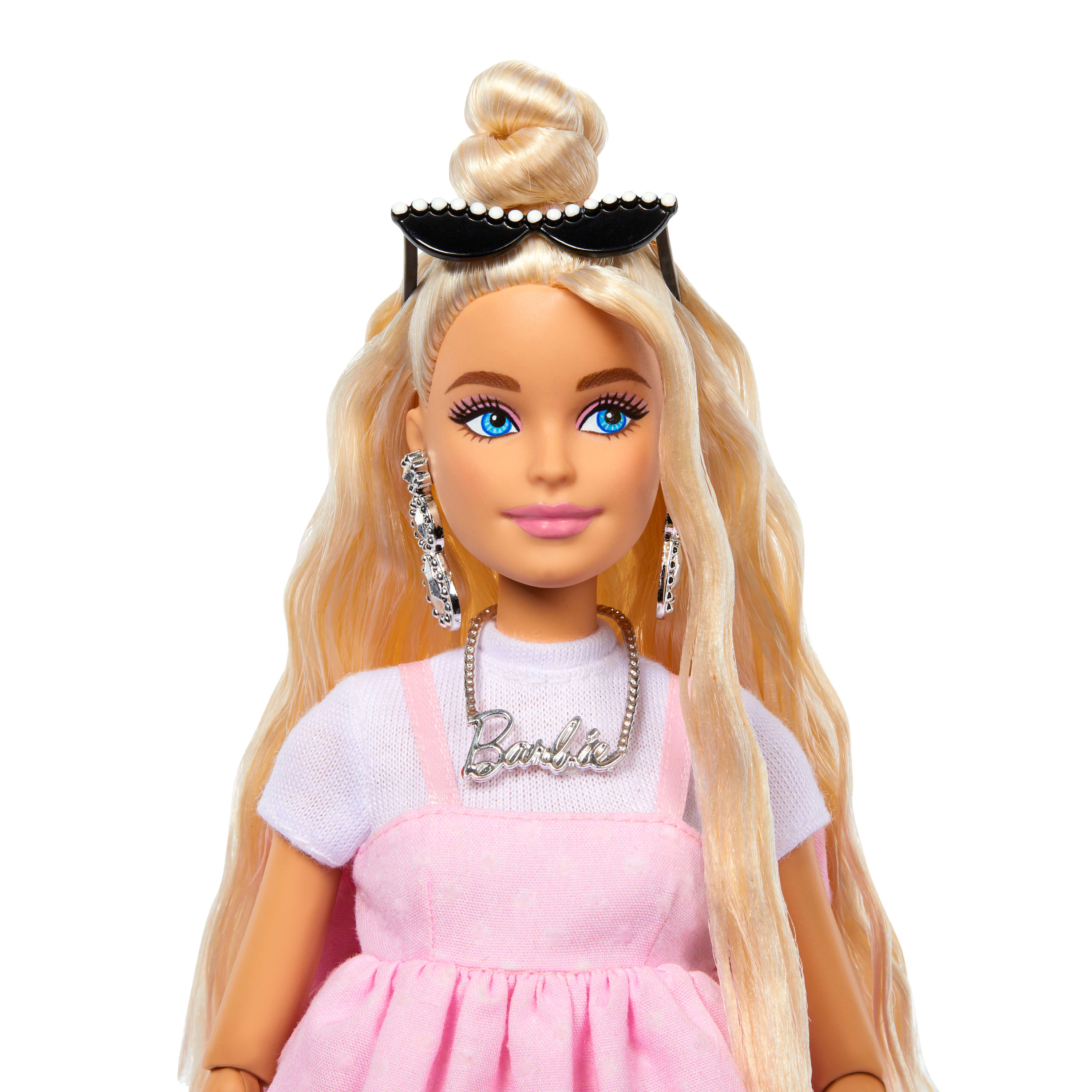 Twarz blond lalki Barbie, noszącej okulary przeciwsłoneczne, kolczyki i naszyjnik.