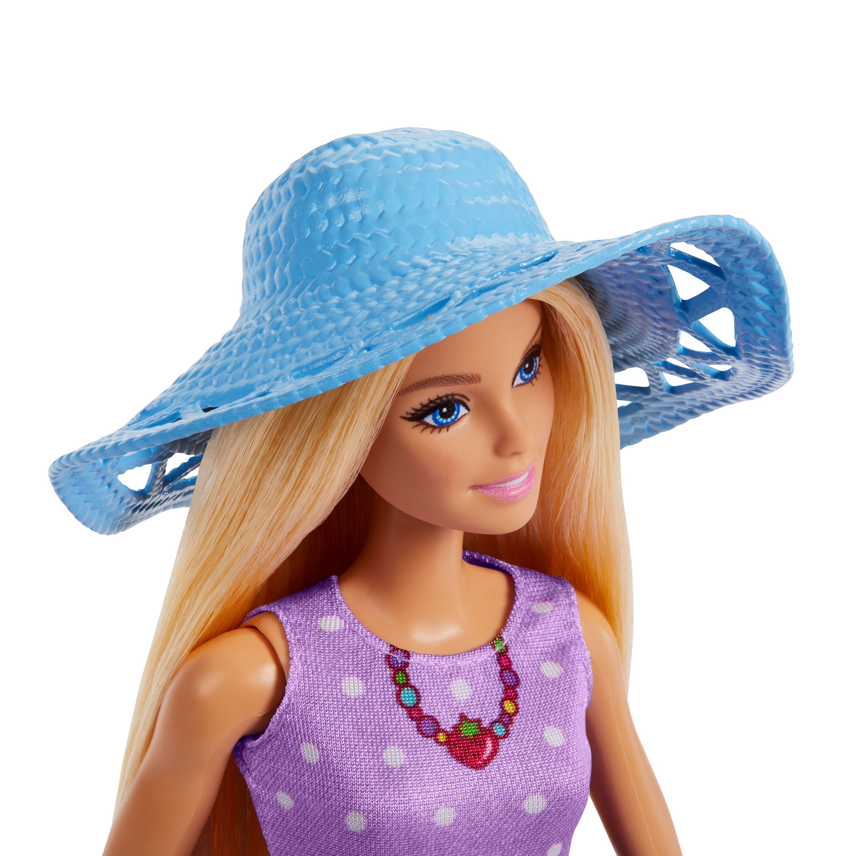 Bambola Barbie con capelli biondi, cappello blu, vestito viola a pois bianchi e una collana. Sfondo bianco.