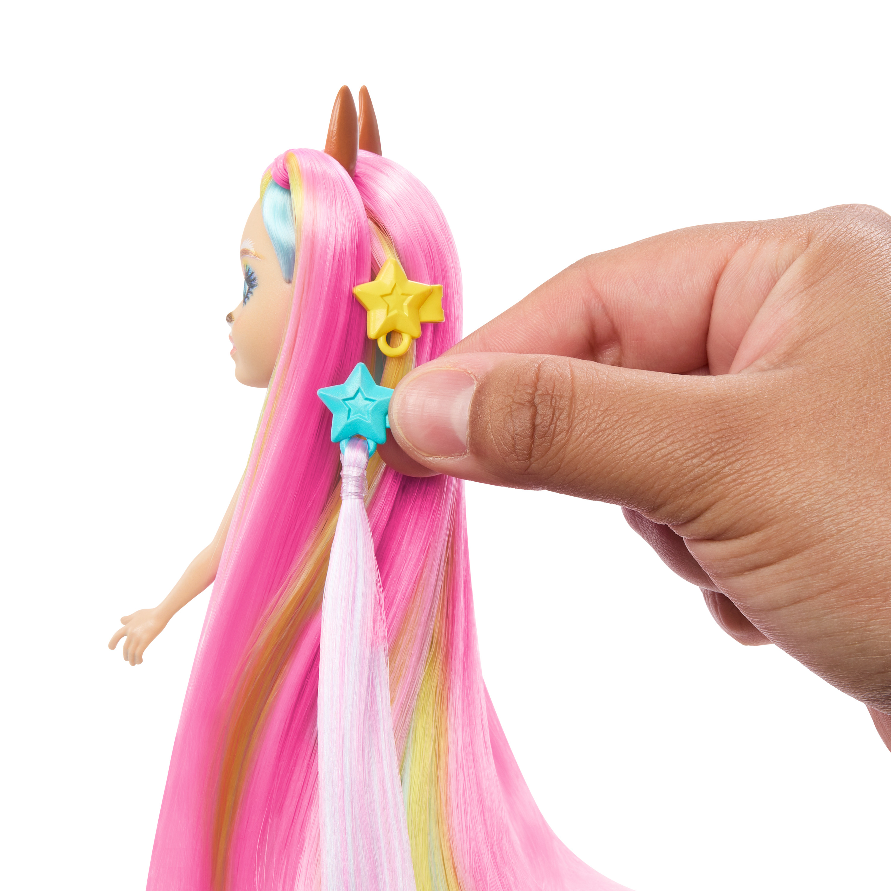 Mano sosteniendo accesorios para el cabello en forma de estrella, colocados en el cabello rosa de una muñeca.