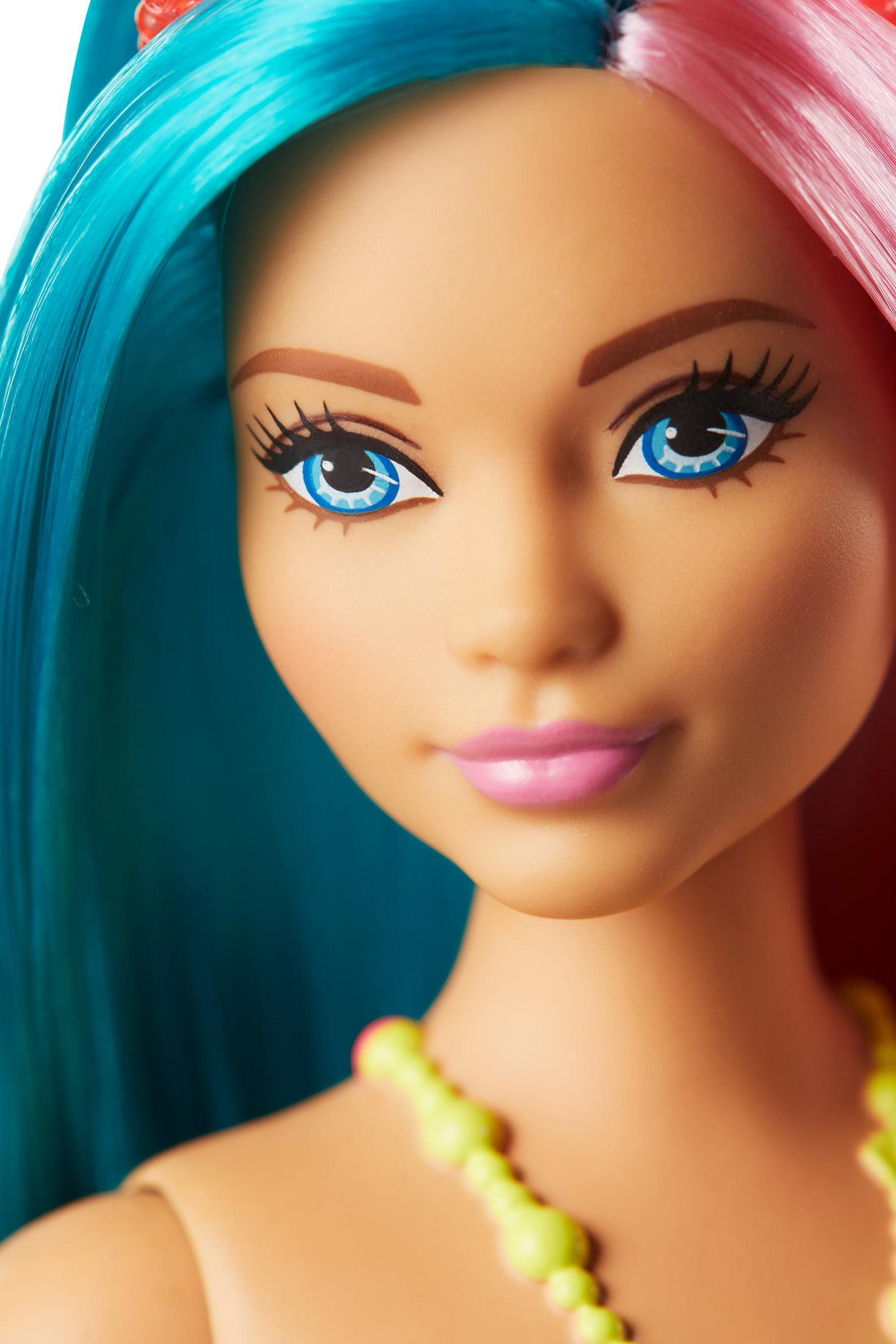 Gros plan du visage d'une poupée Barbie avec des yeux bleus et des cheveux bleus et roses.