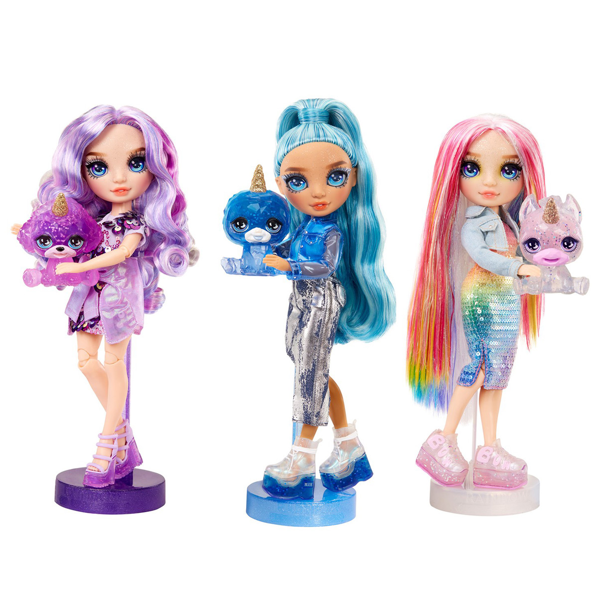 Trzy lalki z niebieskimi, fioletowymi i tęczowymi włosami. Każda lalka trzyma zwierzaka i stoi na stojaku.