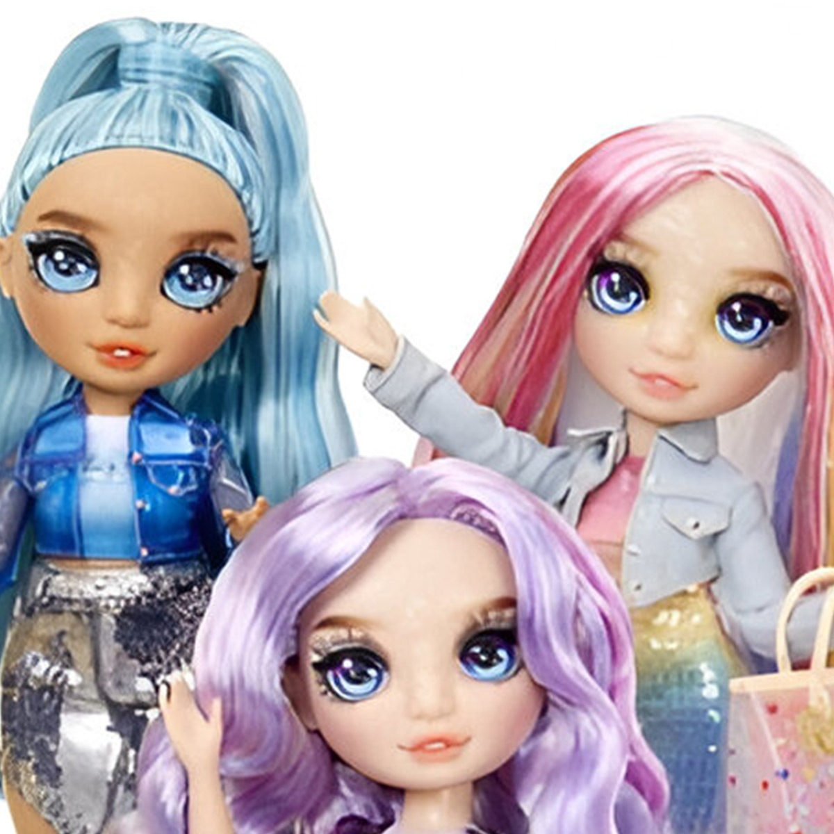 Trzy lalki o różnych kolorach włosów: niebieskim, różowym i fioletowym. Mają duże oczy i się uśmiechają.