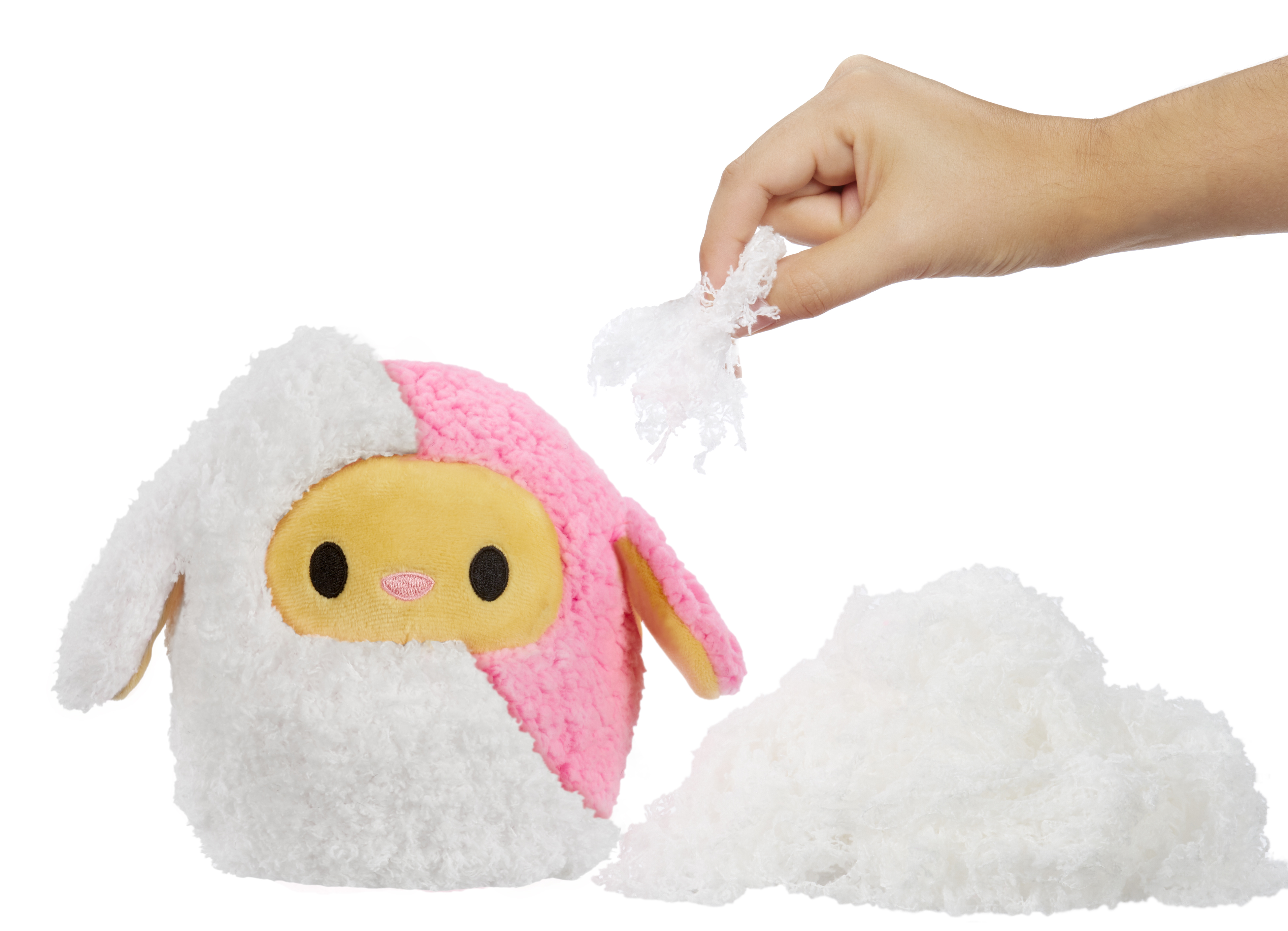 Ręka wyciąga puszyste, białe wypełnienie z różowo-białej pluszowej zabawki w kształcie owcy.