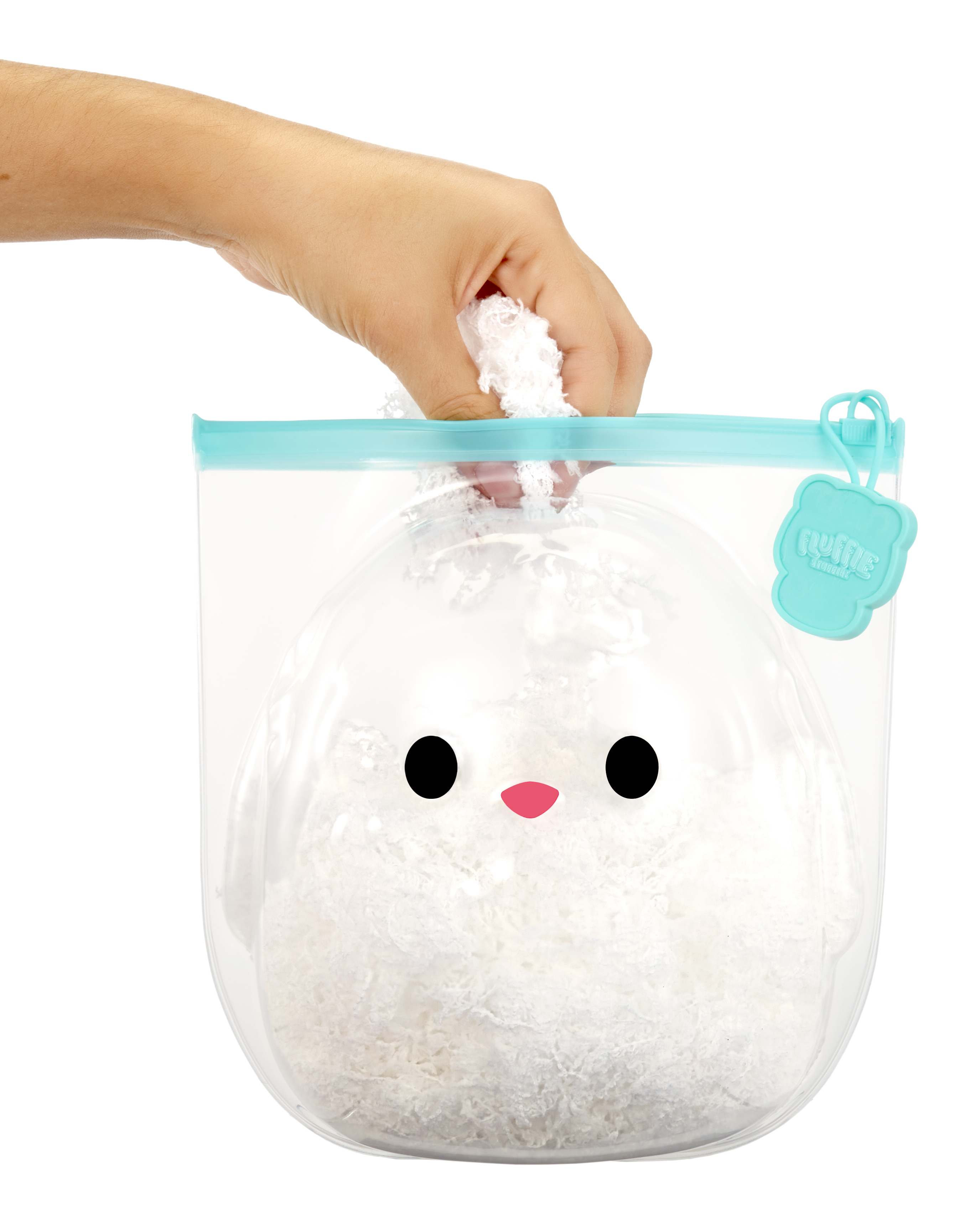 Ręka trzymająca torbę z białą pluszową zabawką w środku.