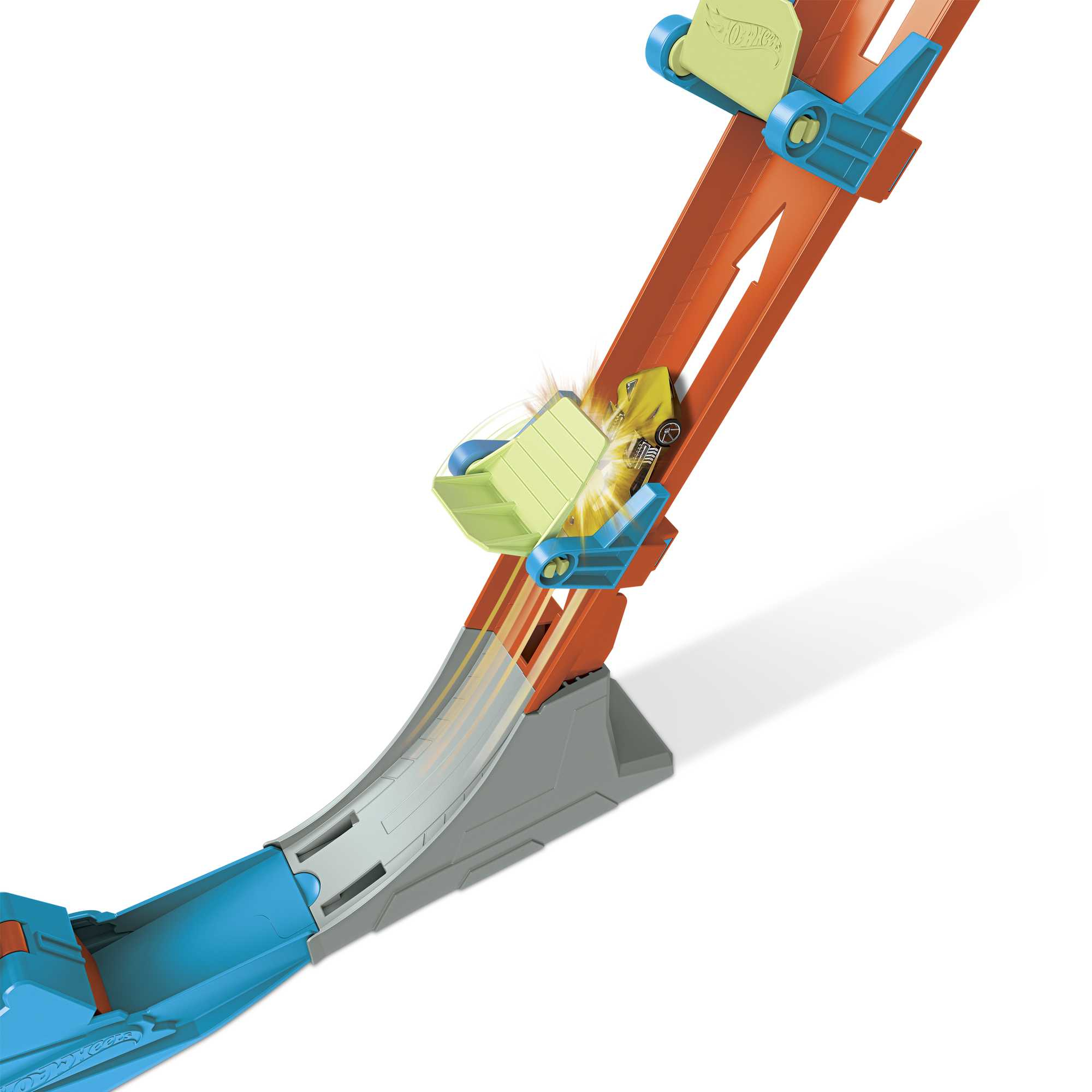 Tor Hot Wheels z samochodem. Samochód jest w powietrzu, przechodząc przez tor z doładowaniem.