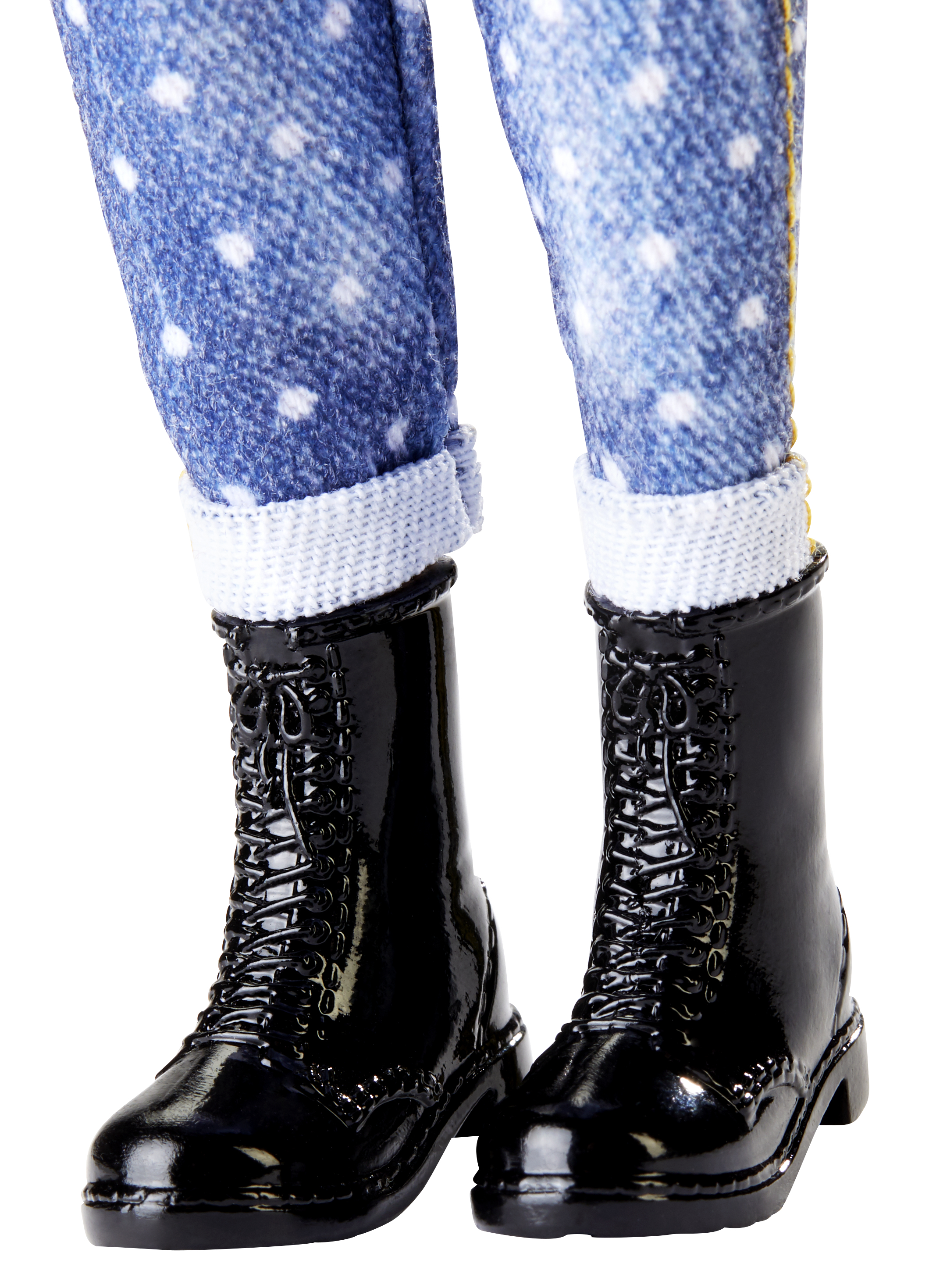 Nahaufnahme der Beine einer Puppe in blauen Jeans mit weißen Tupfen und schwarzen Schnürstiefeln.