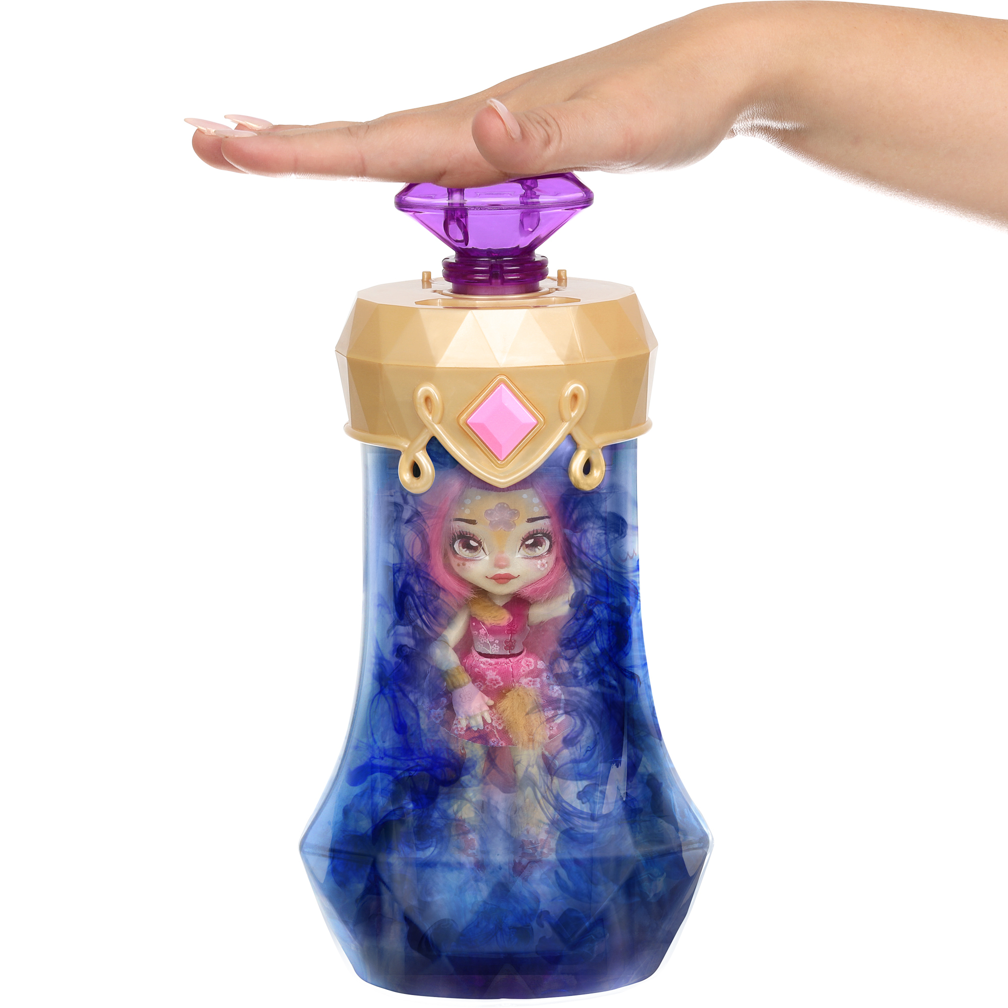 Dłoń nad butelką Mixies Pixlings, z lalką w środku. Lalka jest otoczona niebieską chmurą.