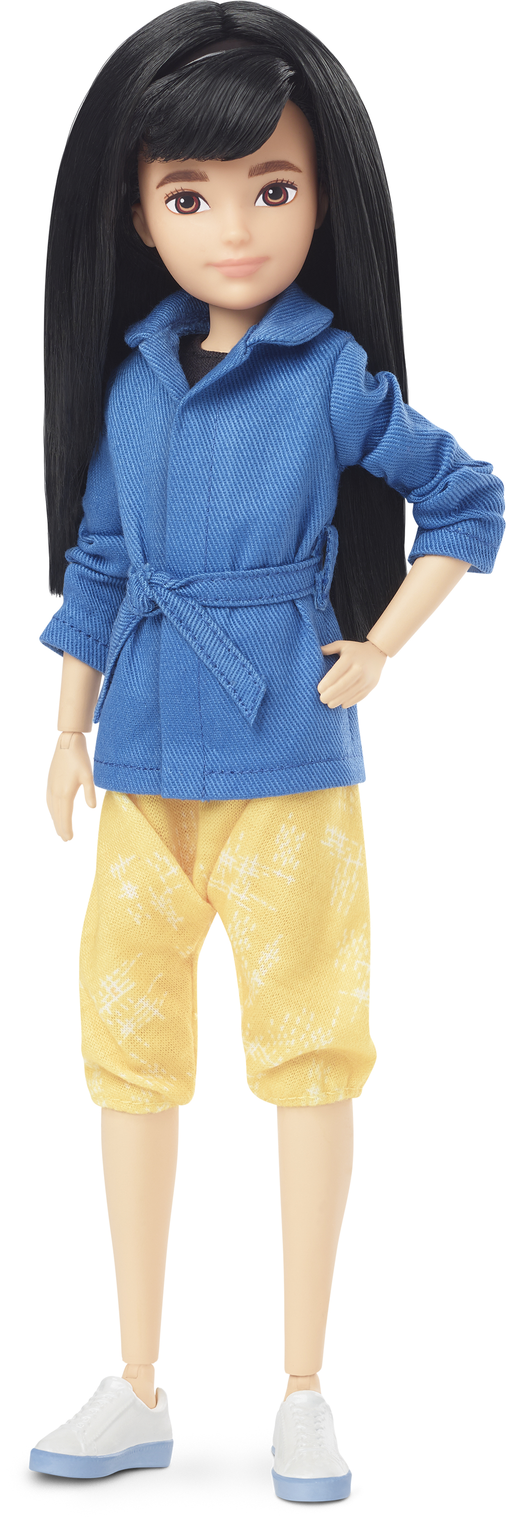 Eine Puppe mit schwarzen Haaren, die eine blaue Jacke und gelbe Shorts sowie weiße Schuhe trägt.