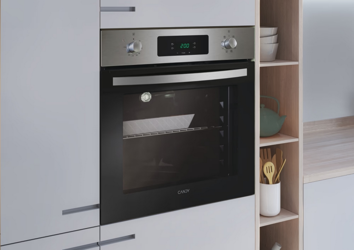 Forno incassato in un mobile da cucina grigio, con display digitale, manopole e interno aperto, marchio 'CANDY'.