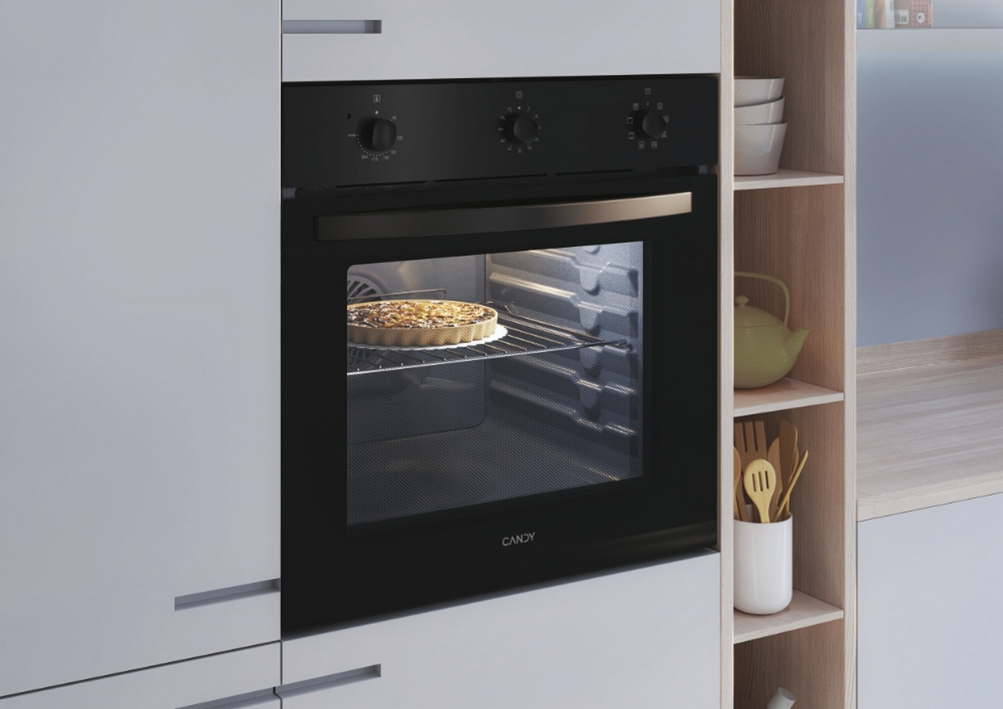 Forno Candy nero con torta all'interno, in una cucina.