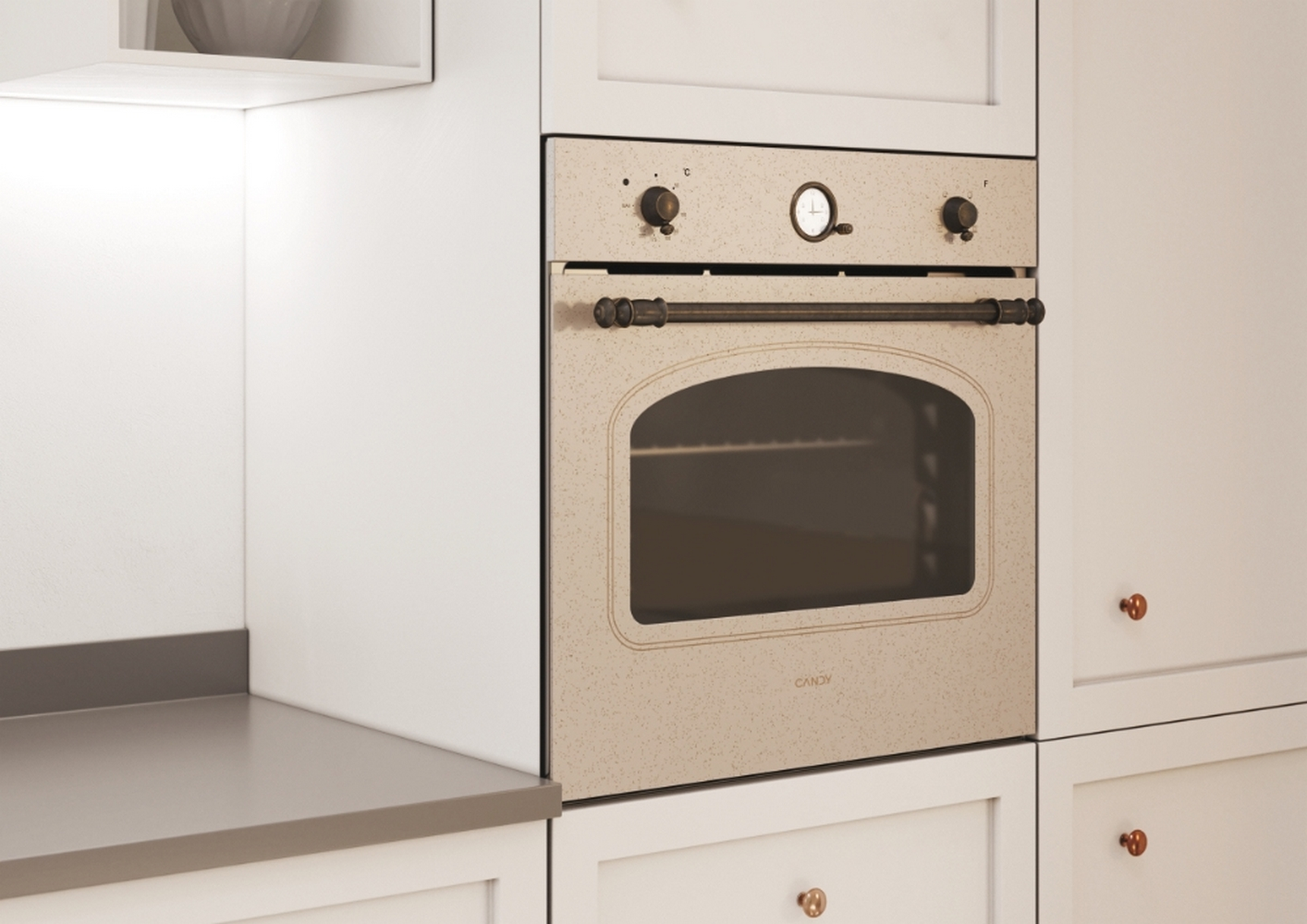 Forno beige incassato in un mobile da cucina bianco. Logo Candy visibile.