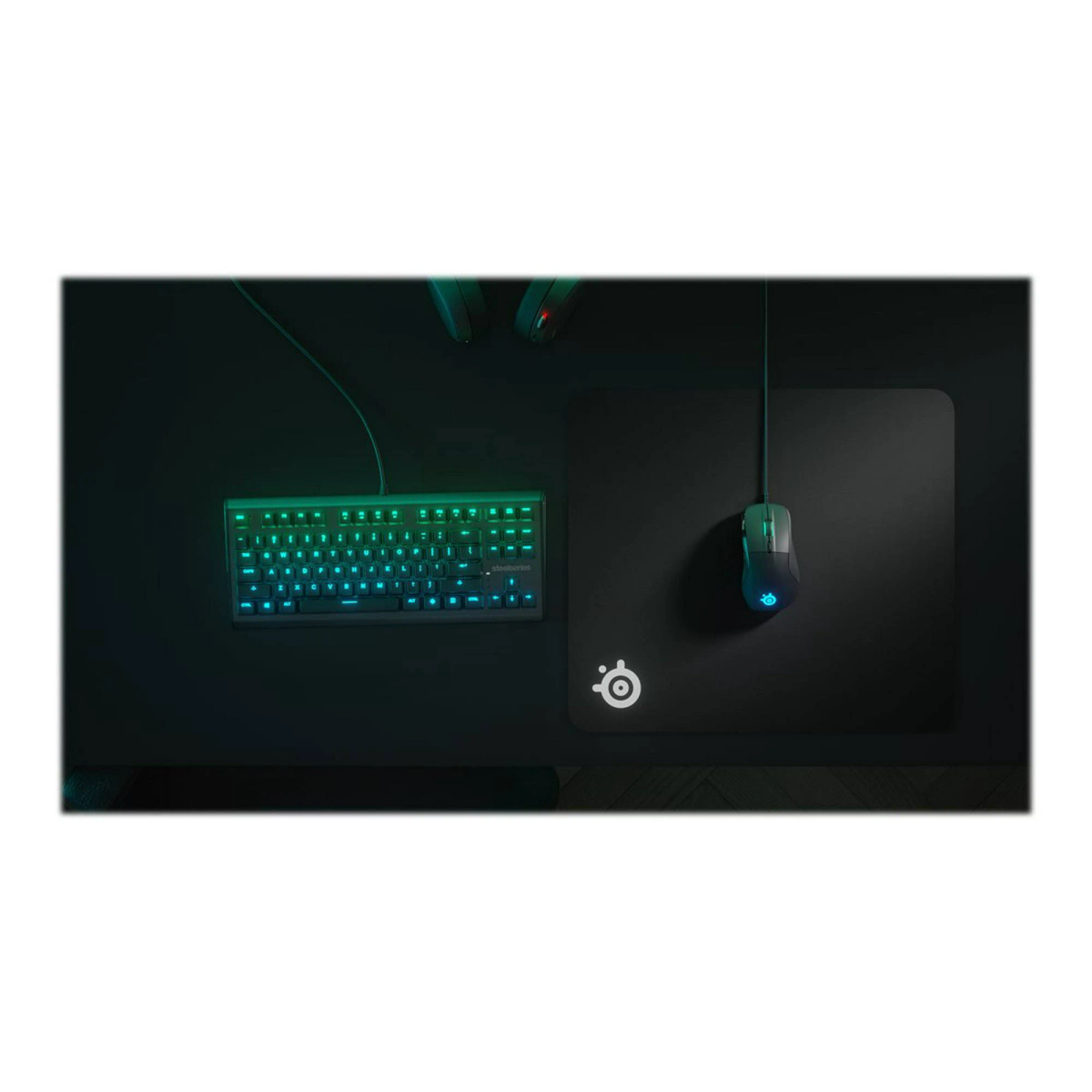 Tastatur und Maus auf einer schwarzen Matte. Grün und blaue Lichter.