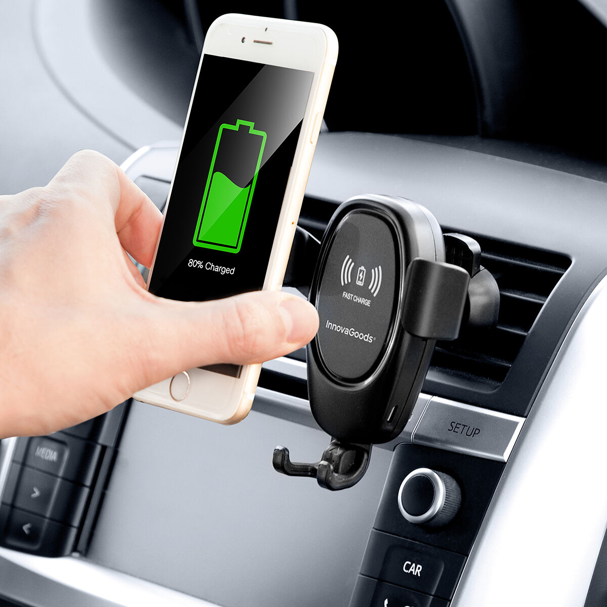 Mano tiene telefono, simbolo carica, in supporto auto.