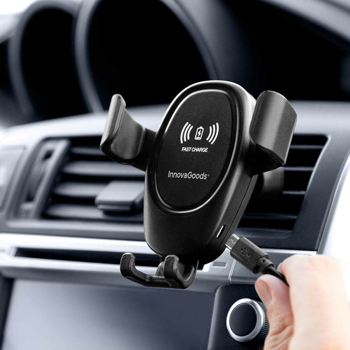 Un supporto per telefono da auto nero con simbolo di ricarica wireless. Un cavo USB è collegato.
