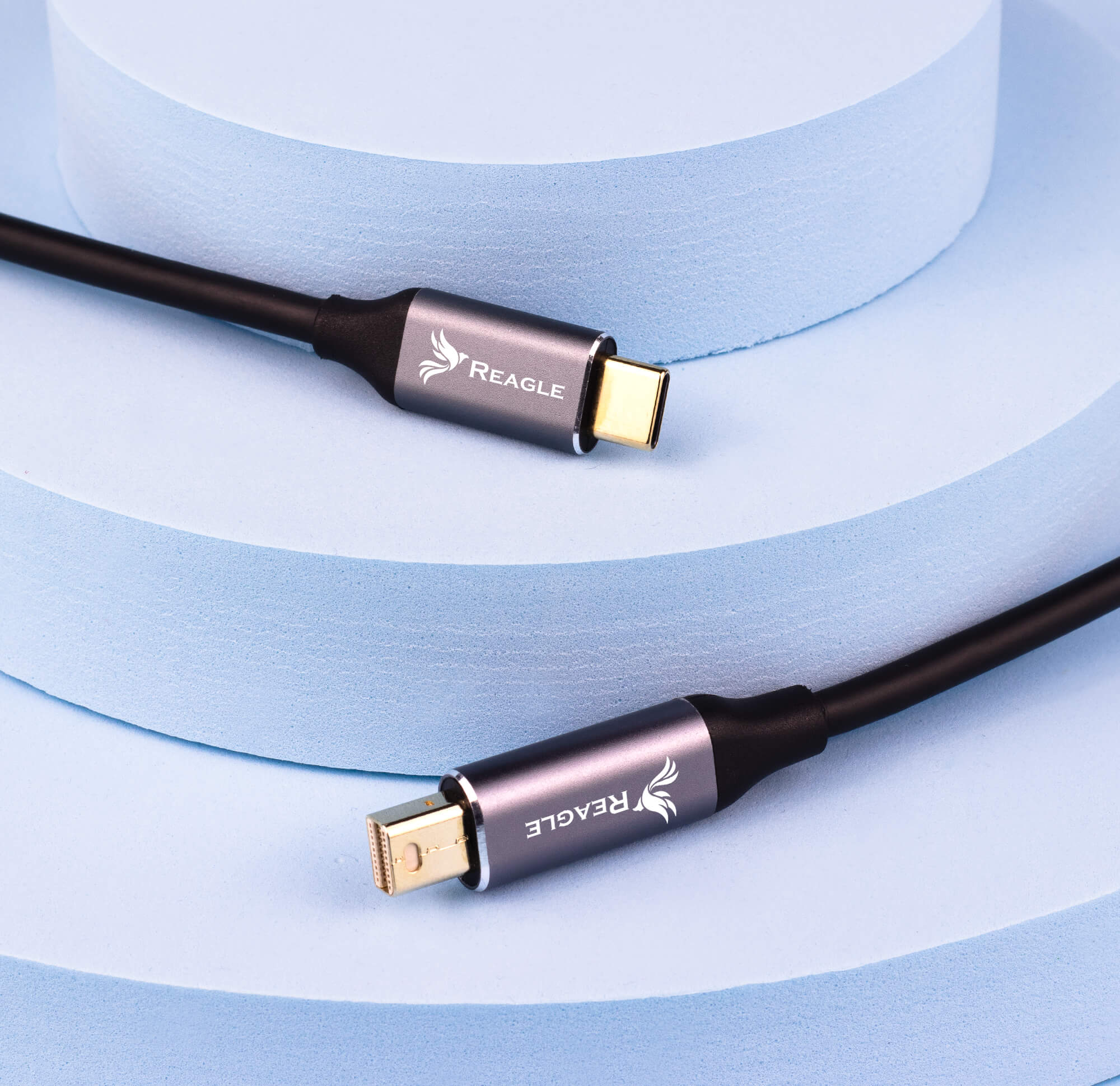 Dwa czarne kable USB-C z etykietami REAGLE na niebieskim tle.
