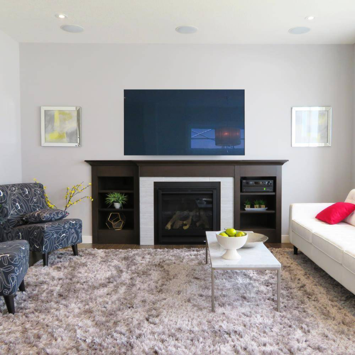 Wohnzimmer mit Kamin und darüber montiertem Fernseher.
