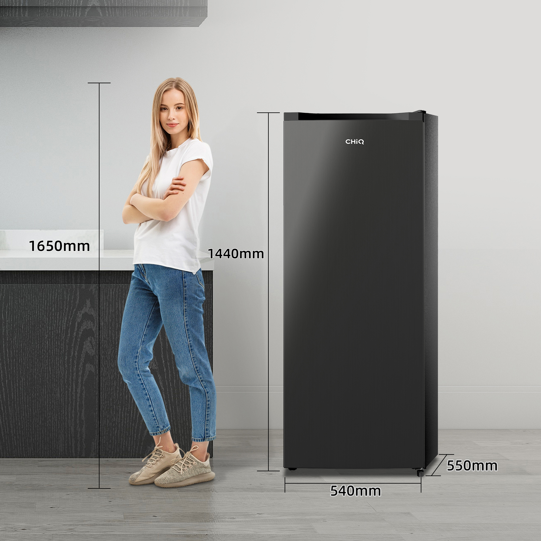 Een vrouw staat naast een zwarte CHIQ-koelkast, met afmetingen van 1650 mm hoog, 1440 mm breed, 540 mm diep.